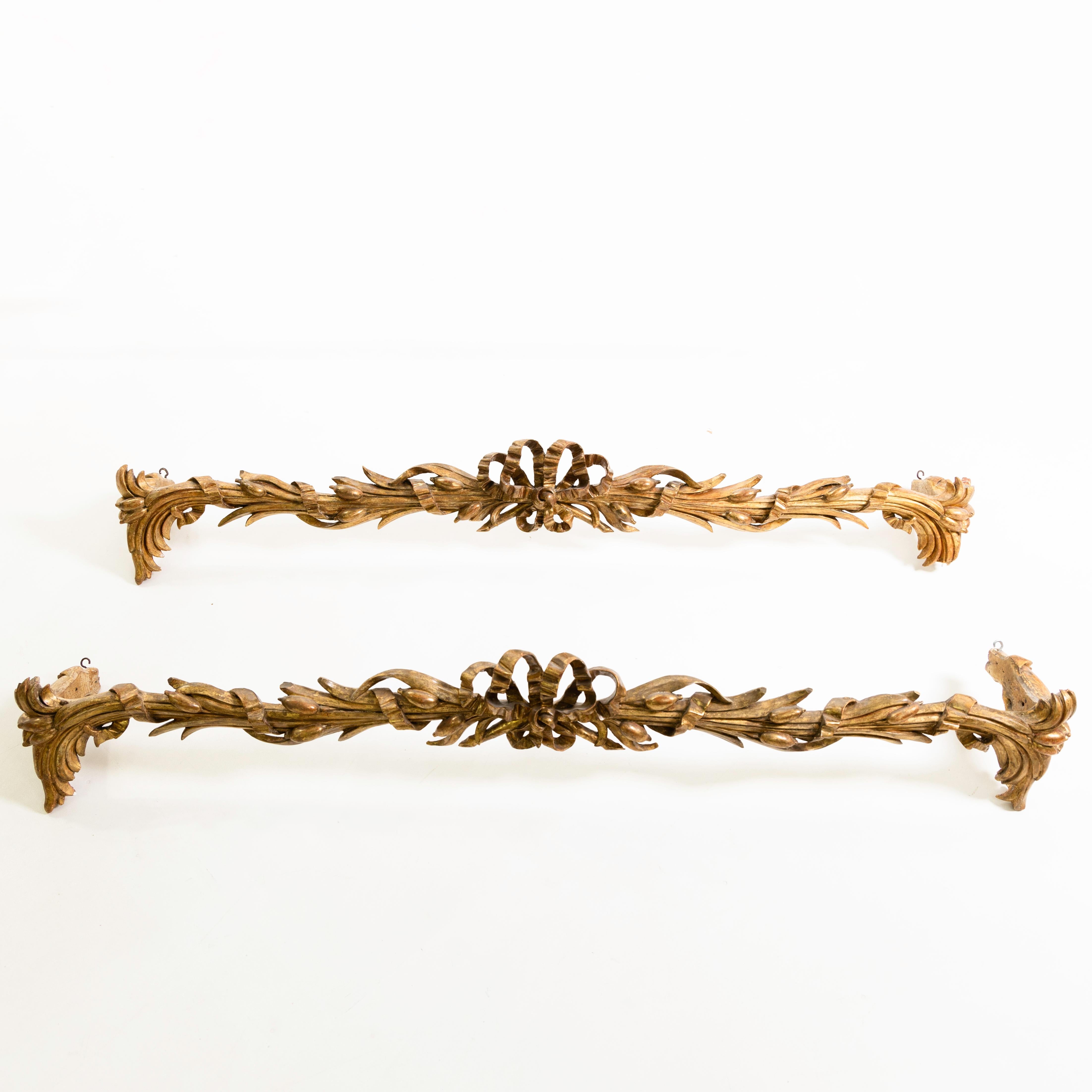 Paire de tiges de rideaux italiennes patinées or avec nœuds et décorations de feuilles.