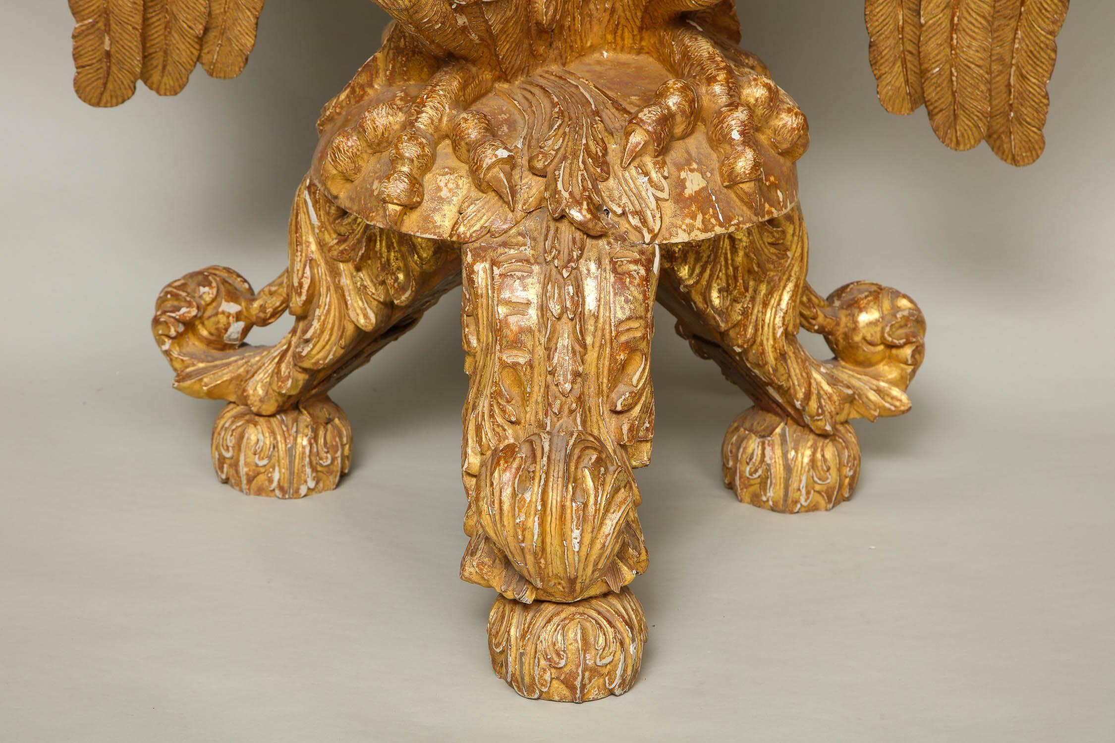 Very fine carved and giltwood 19th century console table, the later Verte Antico over thumb molded platform with half flower and swag carving, the sides with laurel garland draped swags, the base with boldly carved eagle standing on a round platform