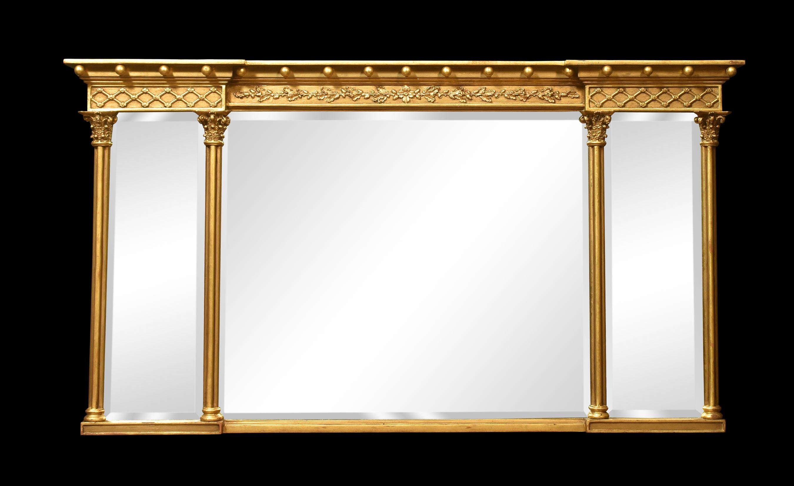 Gilded overmantel mirror, the projecting molded cornice with ball detail above a relief decorated frieze. To the three beveled mirror plates flanked by reeded half pilasters.
Dimensions
Height 33.5 Inches
Width 60.5 Inches
Depth 4 Inches.
