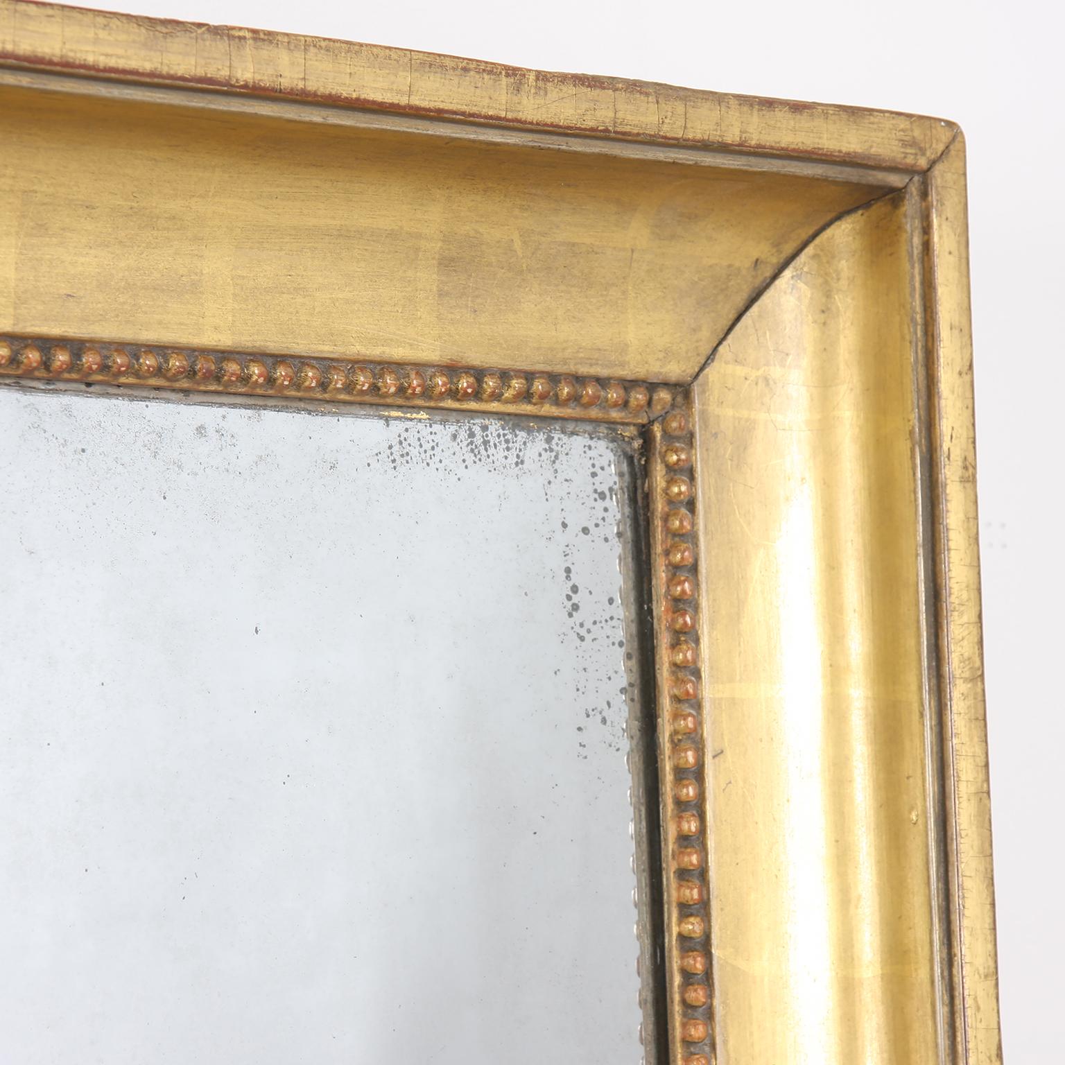 French 19th century giltwood mirror with original mercury plate. It features a lovely plain frame, with bullet beading and beautiful gilding.