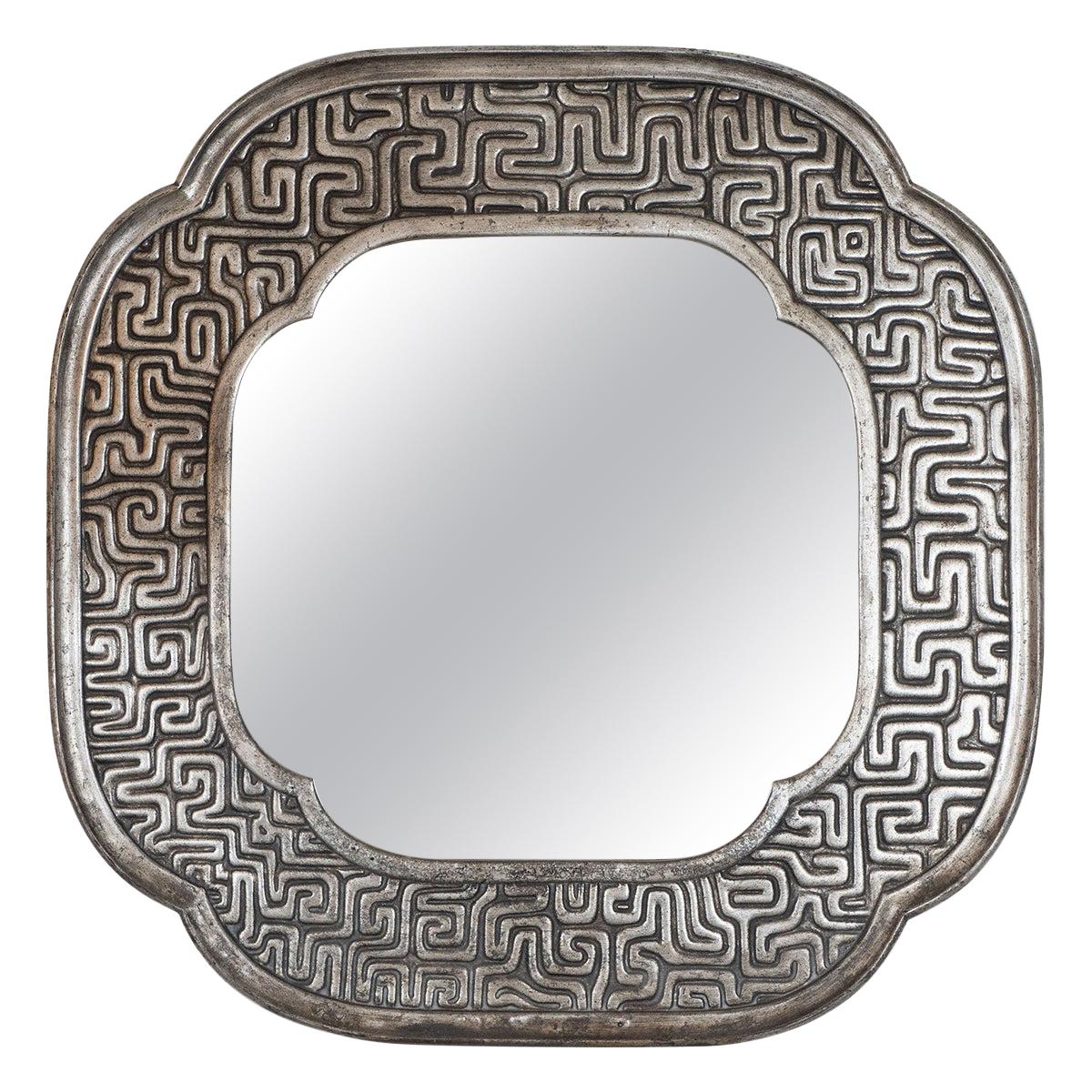 Miroir entouré de motifs géométriques en bois doré