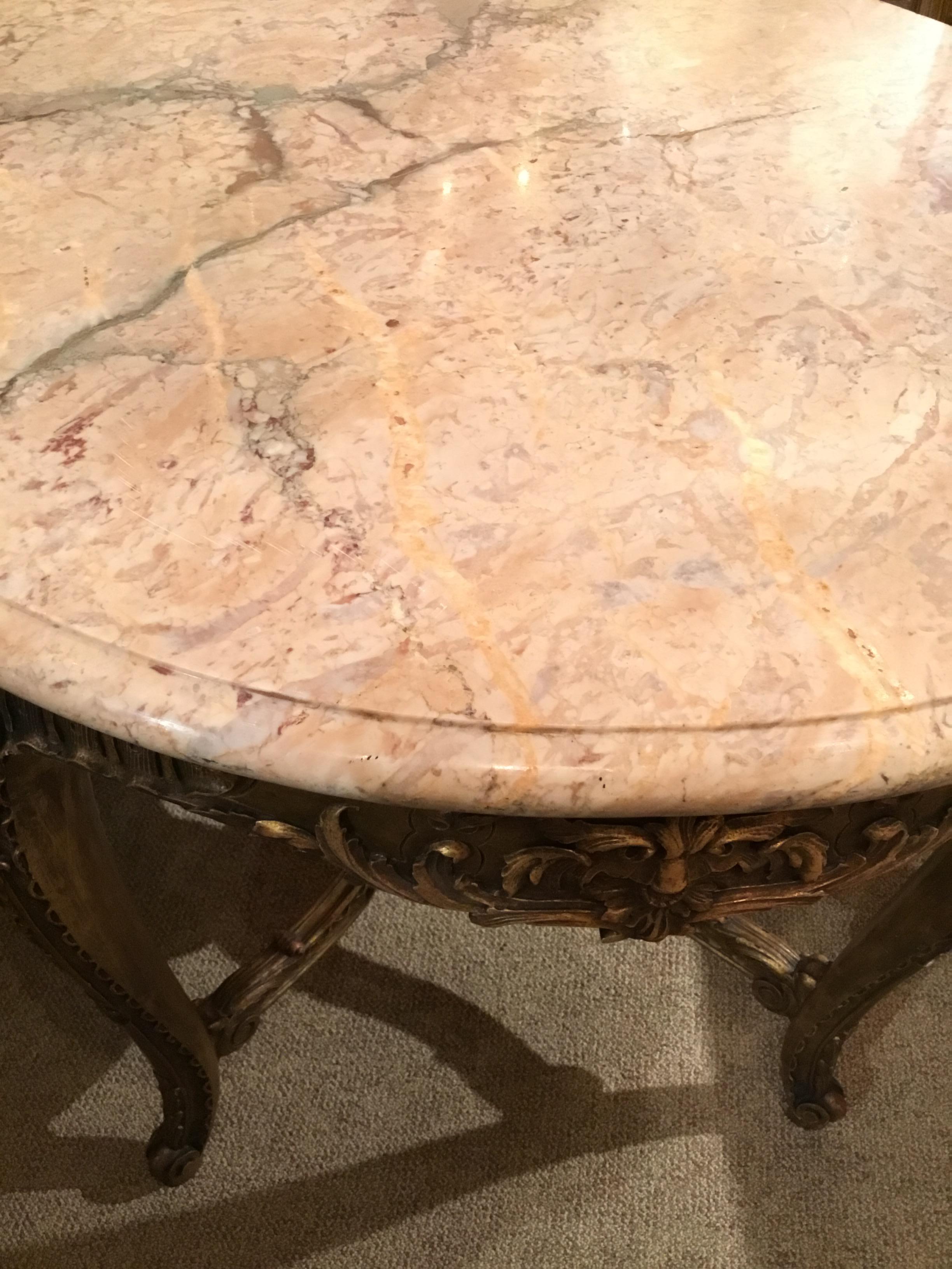 Exceptional Louis XV style center table with a round marble top. Crafted of giltwood and carved in a
raised foliate motif. The curved cabriole legs are joined by a nicely contoured cross-stretcher.