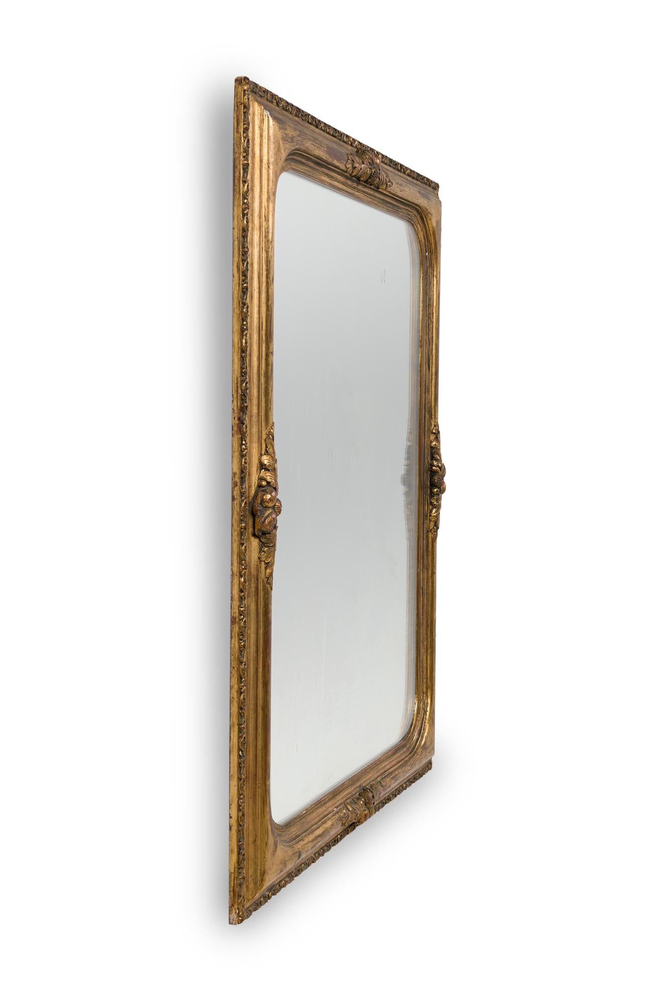 Specchio vittoriano francese in legno dorato con angoli arrotondati e un disegno floreale intagliato al centro su ogni lato della cornice