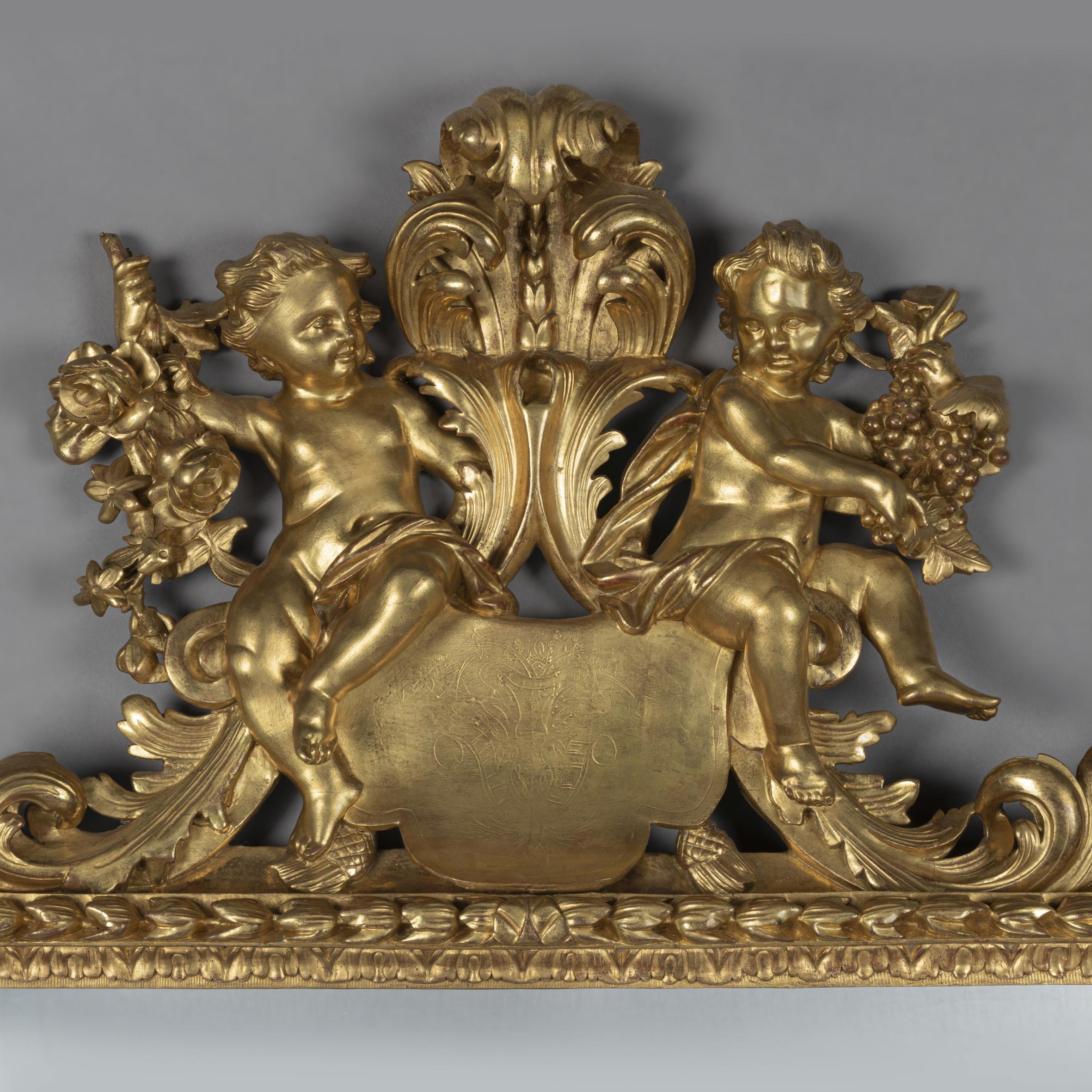 A fine North Italian, Baroque Revival, carved giltwood mirror allegorical of the seasons.

This finely carved mirror has a rectangular mirror plate within a harebell running border surmounted by a finely carved fronded acanthus cresting with two