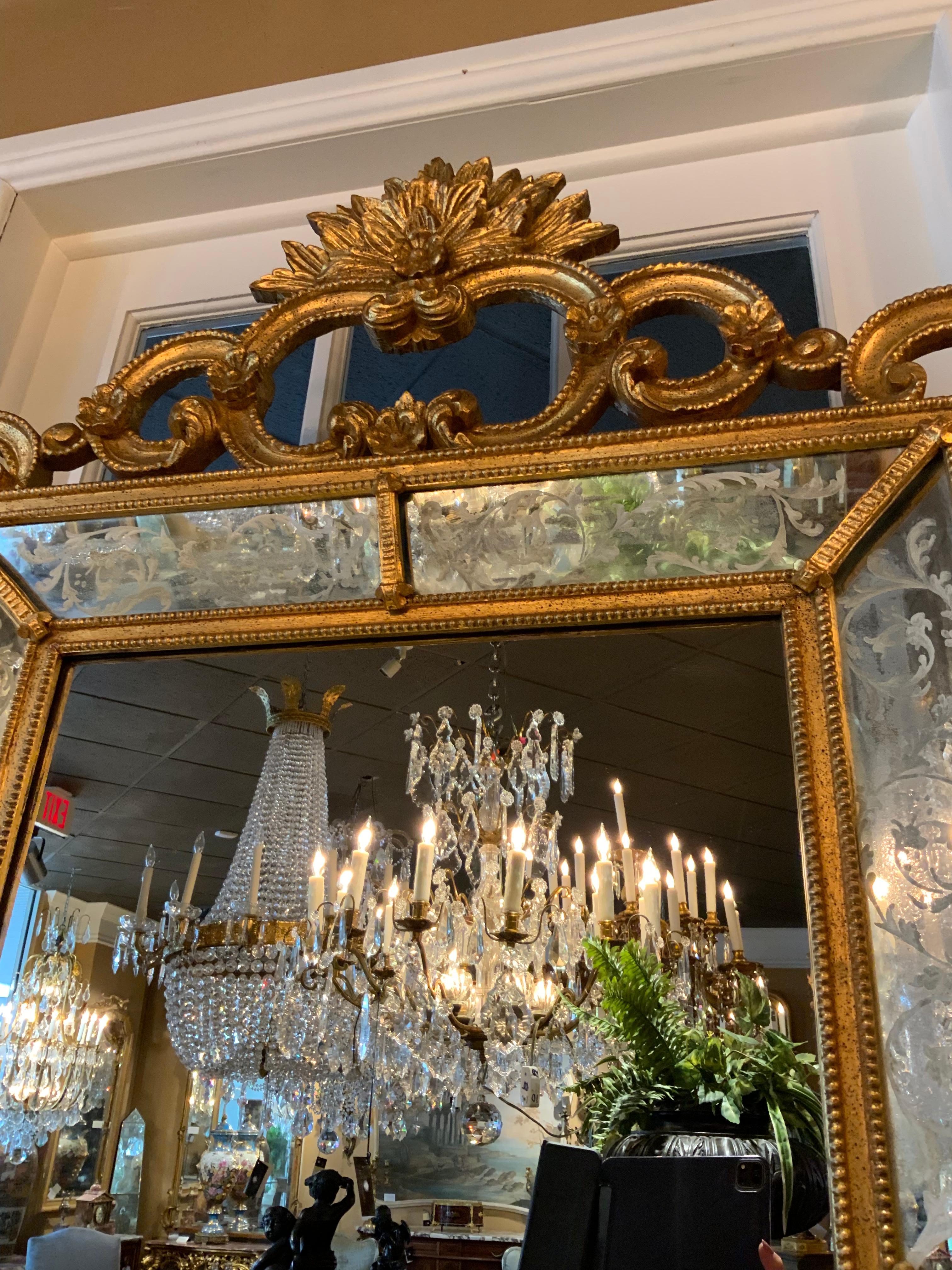This piece is carved in the Venetian rococo taste with curved and 
Scrolling frames with foliate detail. It has double framing with inset
Mirror that has hand etching which has delicate aging. The top
Crest has a burst of foliate leaves. The