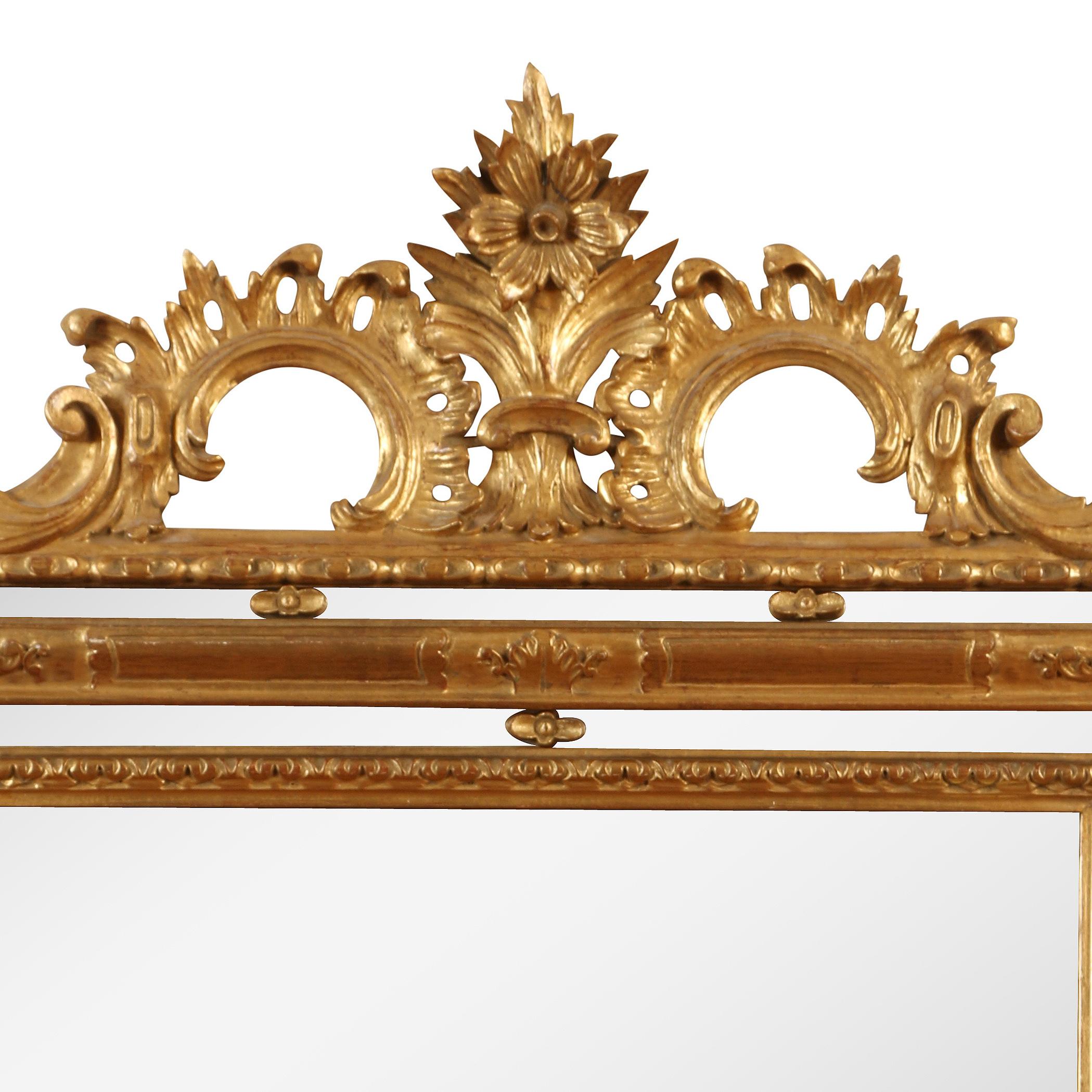 Giltwood rectangular Regence style mirror with a triple frame. Scroll and flower detail to crown.