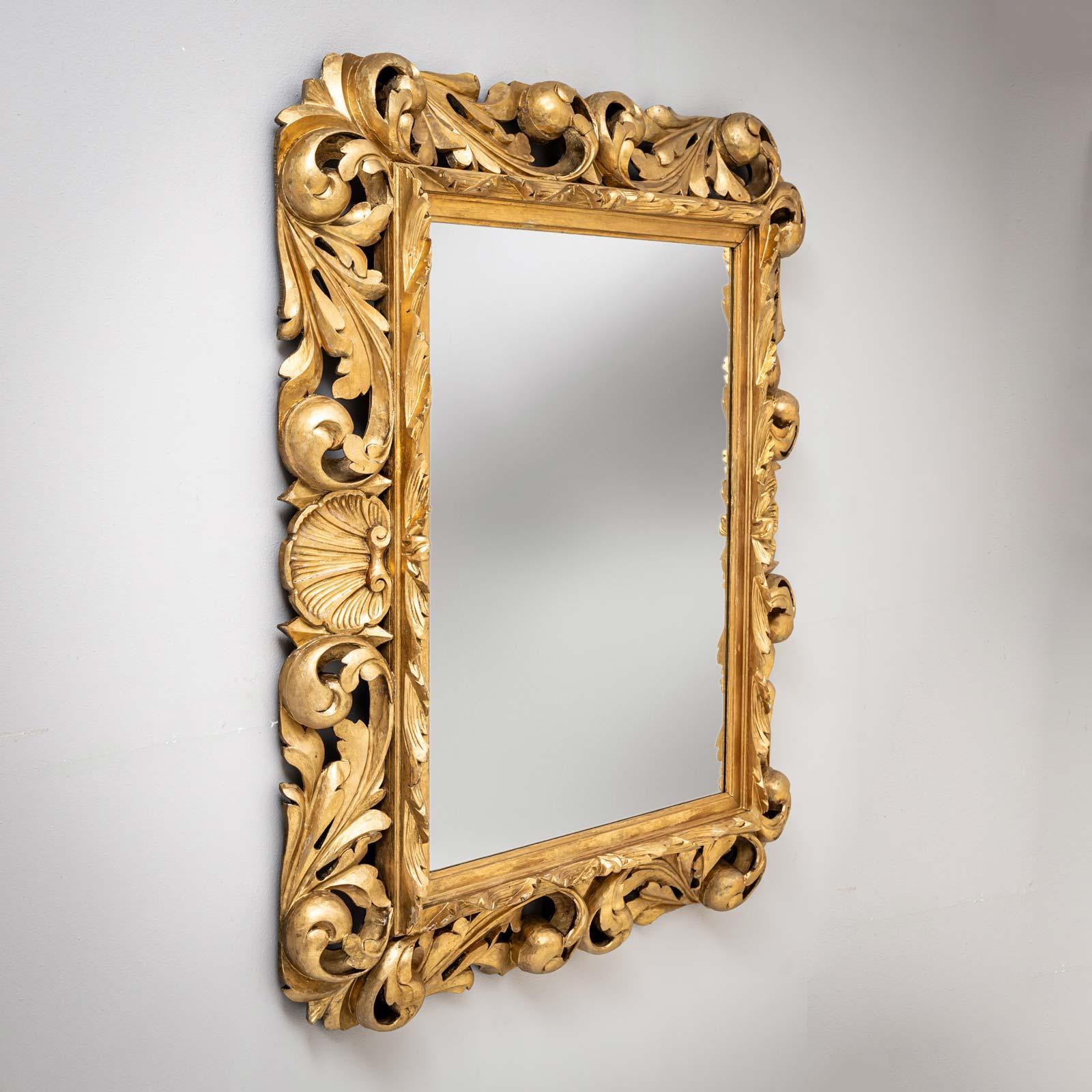 Grande specchio in legno dorato con ornamenti di foglie e conchiglie intagliate in stile Florentine. Specchio moderno. 