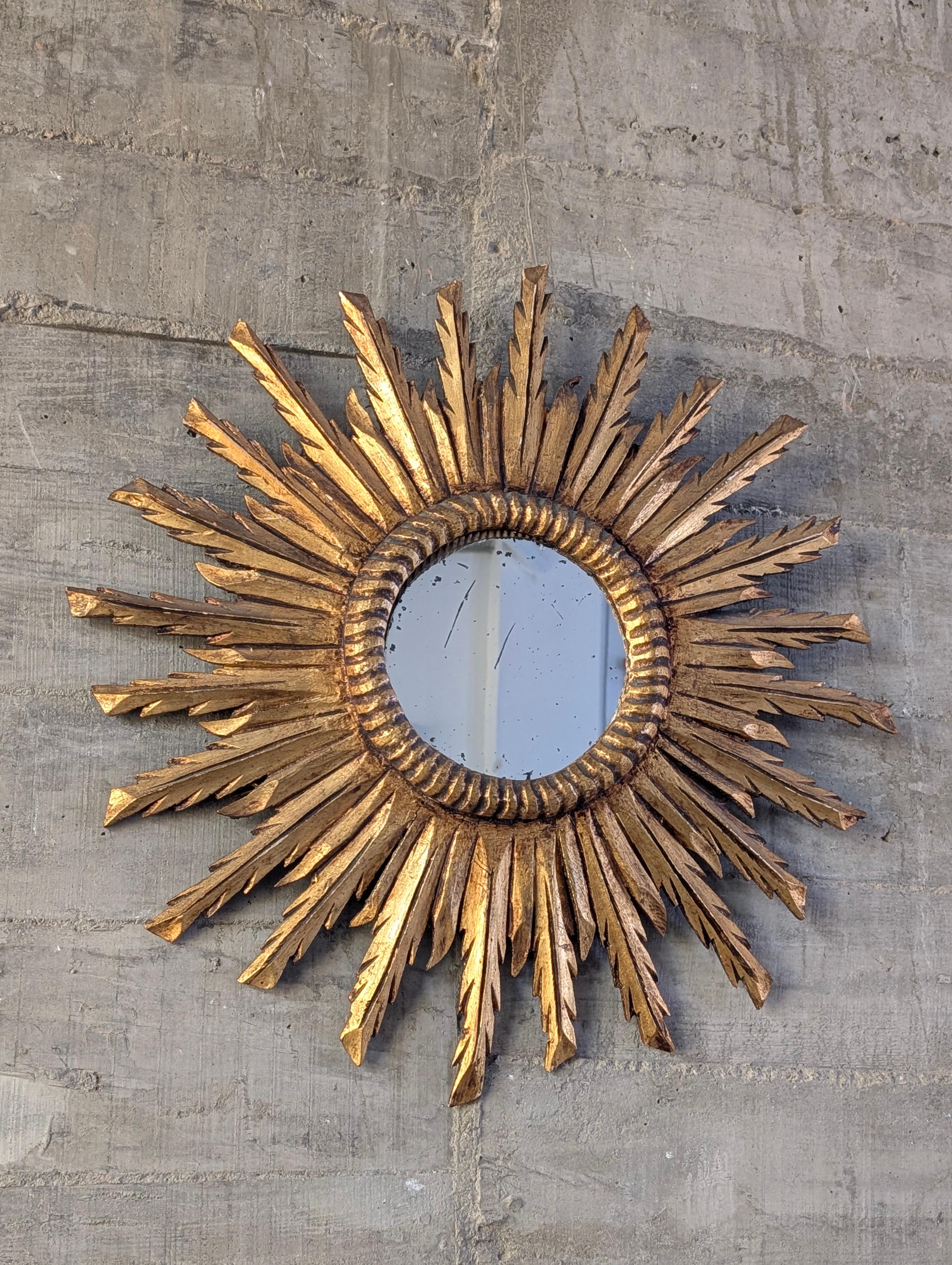 Descripción en inglés:
Specchio a raggiera intagliato nel legno e rifinito con foglia d'oro, realizzato in Spagna intorno al 1950. Presenta una composizione radiale a due livelli che aggiunge struttura e movimento, con uno specchio centrale