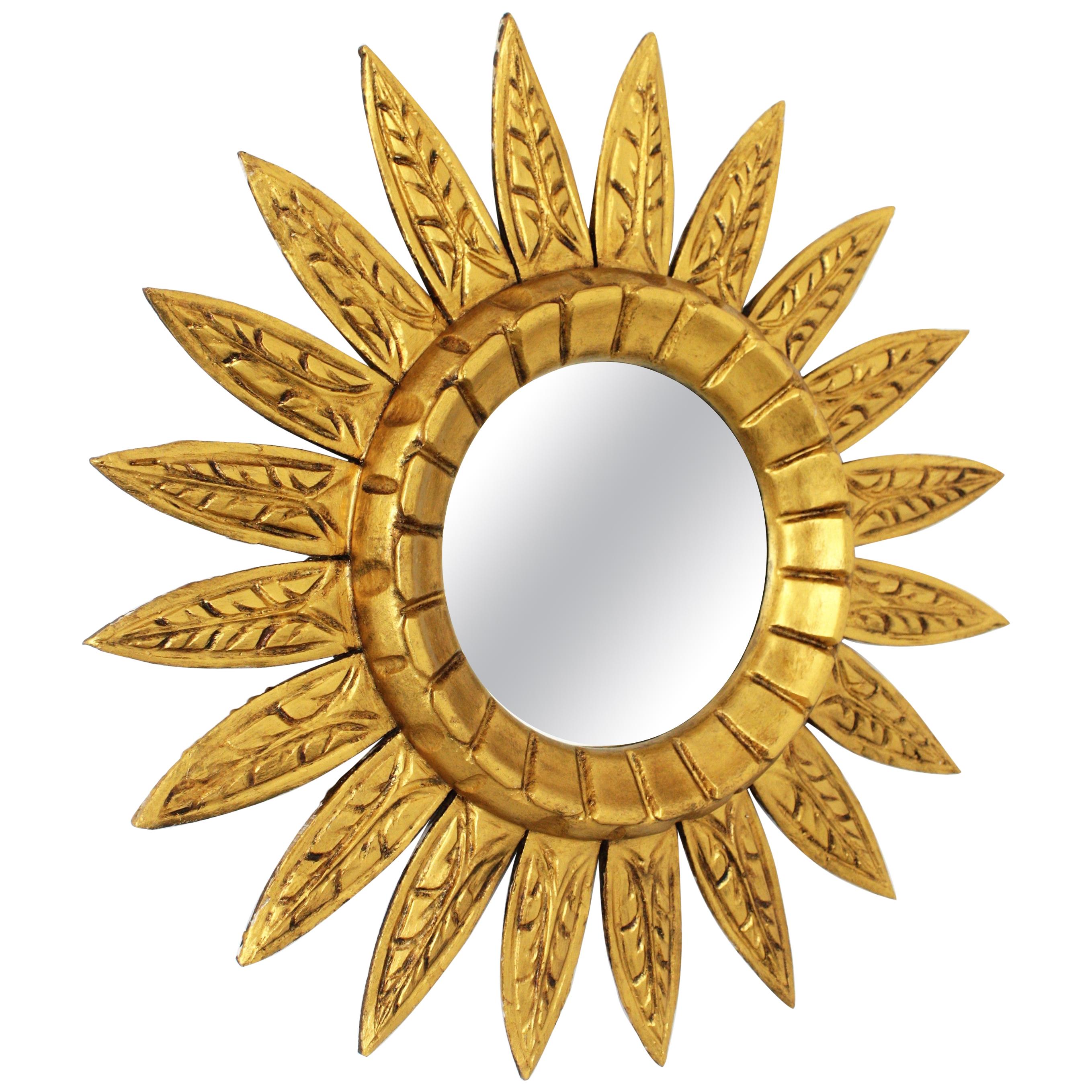 Spanish Mid-Century Modern carved giltwood sunburst flower mirror, Spain, 1950s-1960s.
A lovely midcentury flower shaped sunburst mirror with gilt finish. It has beams with carved decorative details and a carved frame pattern surrounding the