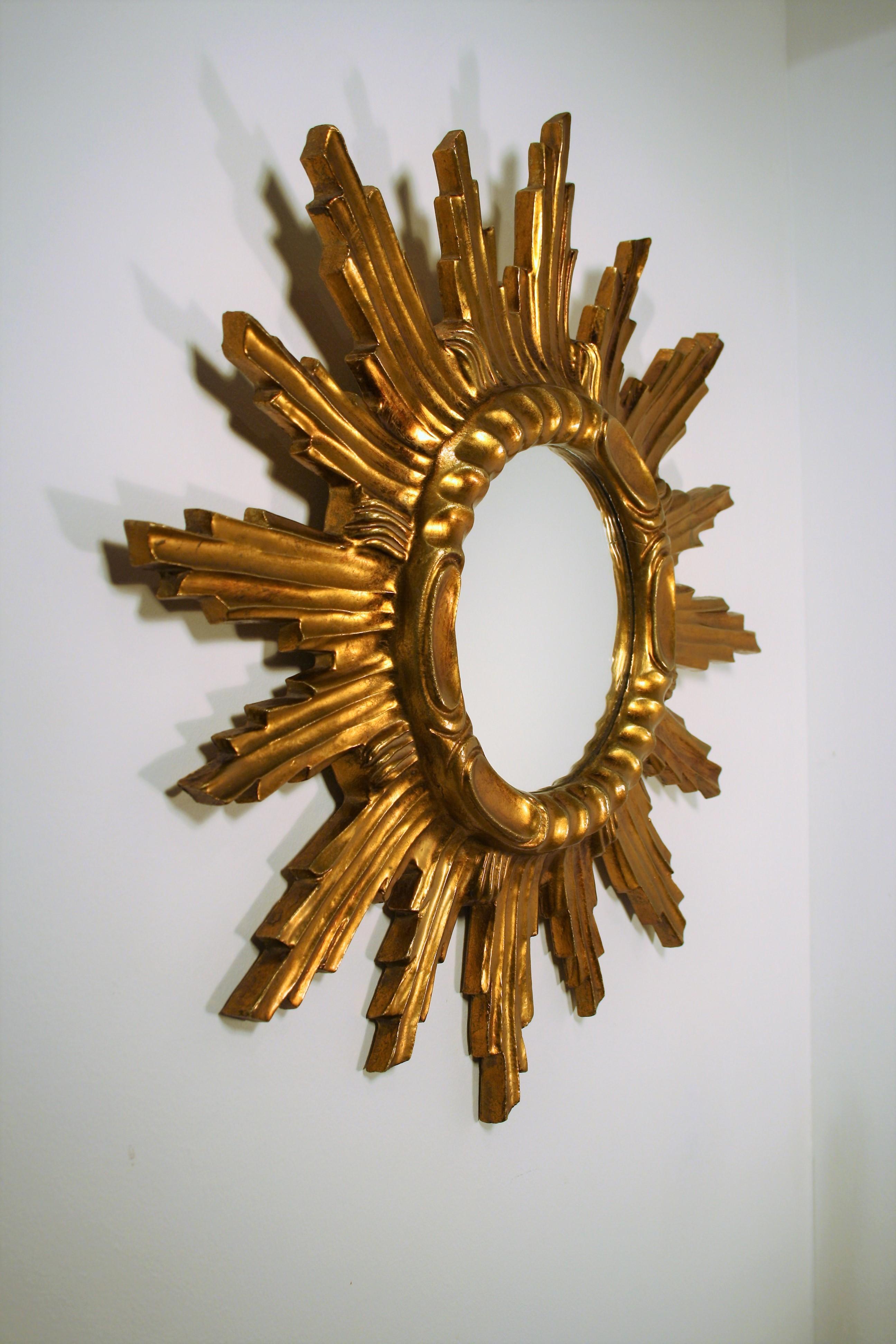Italian sunburst mirror with beautiful patina in gilt wood and chipboard wood from the early 1960s.