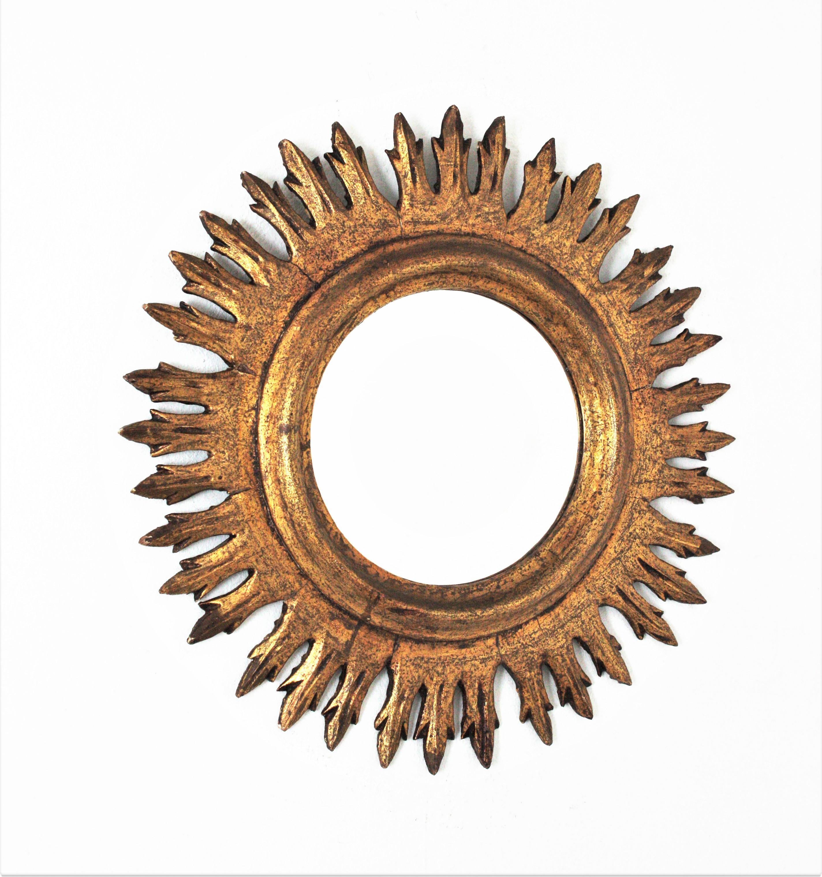 Round Sunburst Mirror, Giltwood, Gold Leaf, Spain, 1960s
Handcrafted sunburst mirror with short rays.
Original gold leaf gilding and nice patina.
This sunburst mirror combines Midcentury and Baroque accents. It will be a nice addition to any