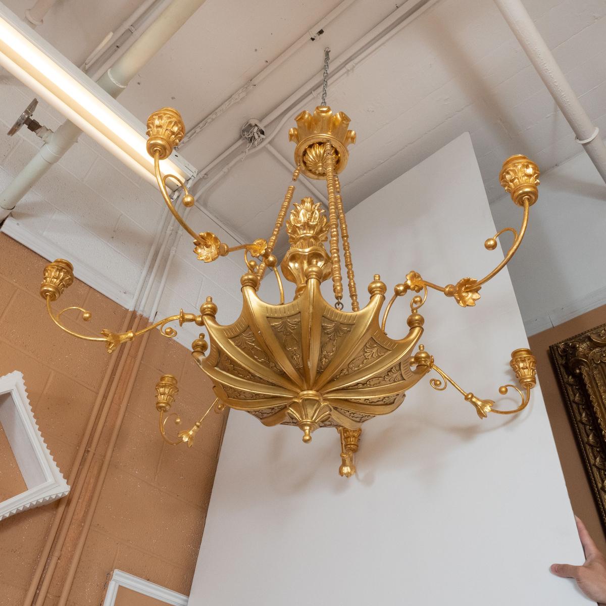 22k gold giltwood woodcarving chandelier with mixed umbrella and foliate motif by master woodworker Carlos Villegas.