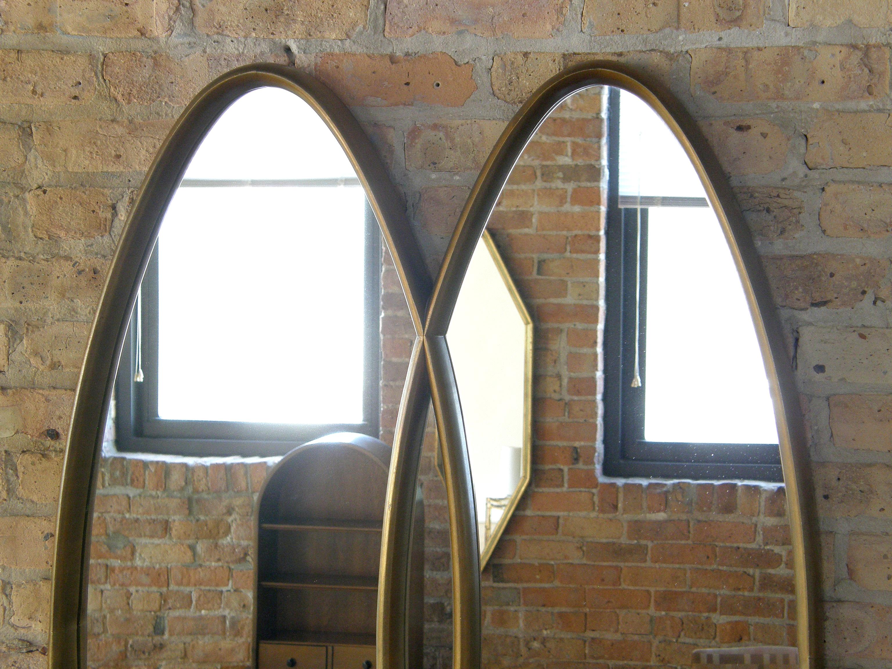 Dieser elegante Wandspiegel aus vergoldetem Holz hat ein Design aus zwei ineinandergreifenden Ovalen. Die Rahmen sind tief, mit einer raffinierten Rundung des Profils. 

 