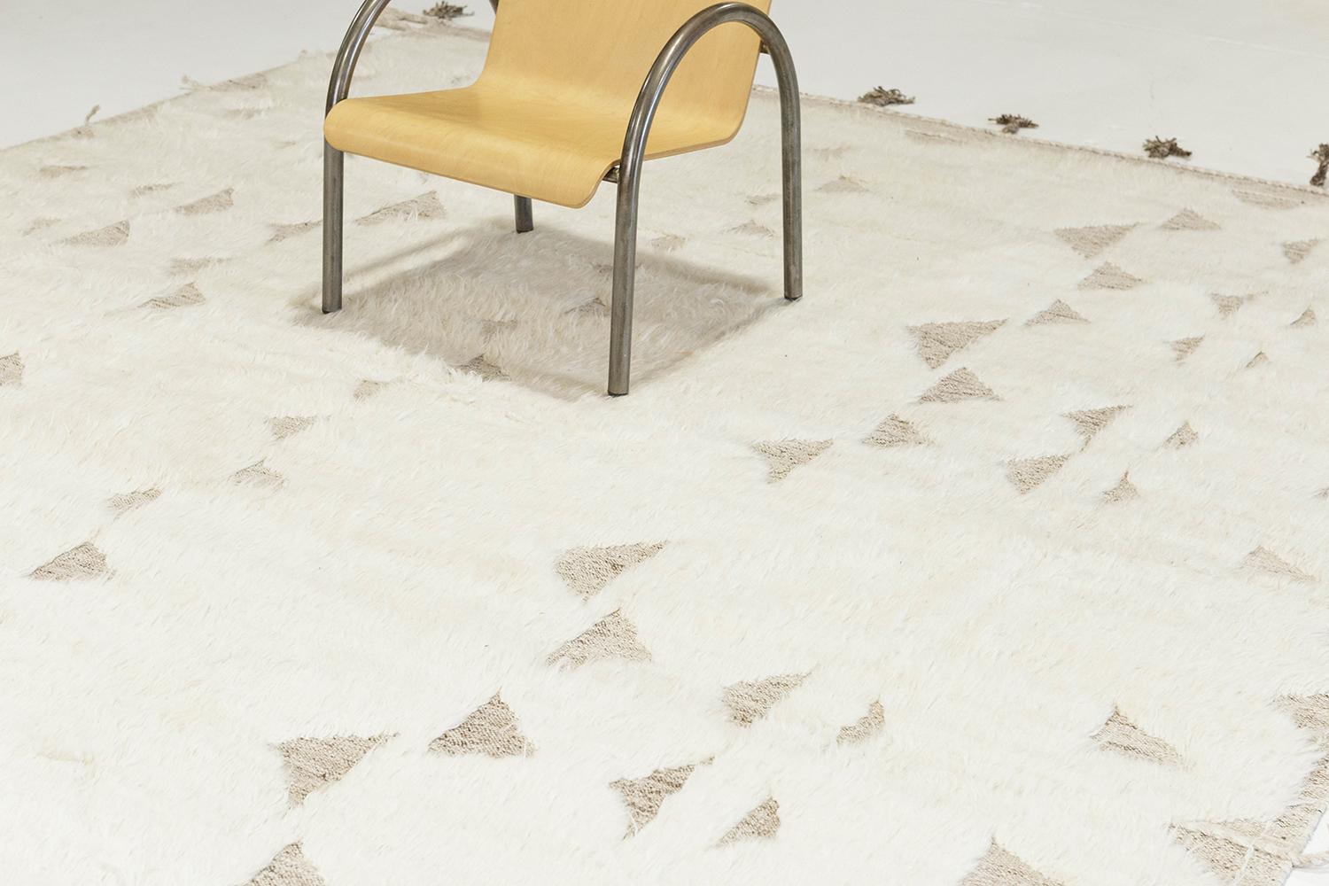 le tapis 'Gimbrala' est un superbe tapis tissé à la main avec des triangles gris en relief entourés d'un velours blanc parfait. De magnifiques glands et des motifs bordés ajoutent une essence opportune et unique au monde du design moderne.