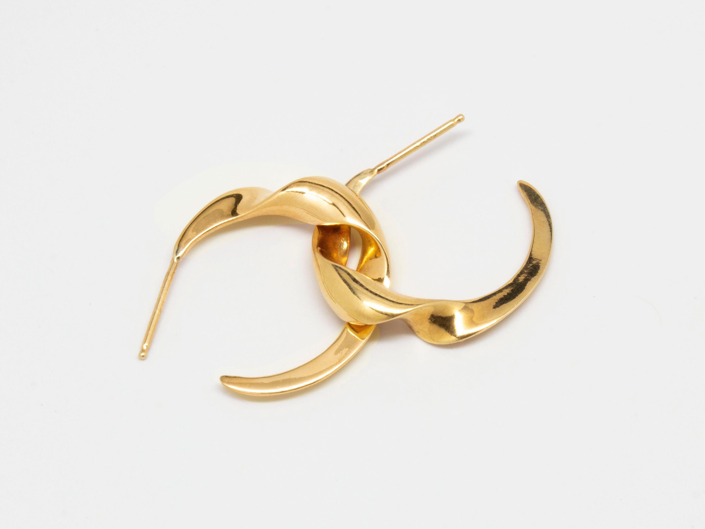 The Swirl Gimmel Hoop Earrings from modern fine jewelry house, Baker & Black. Fun everyday hoops inspired by Baker & Black's beloved Swirl Gimmel Ring. This listing is for all yellow gold hoops, mixed metal photos are for reference.

• measures 22mm