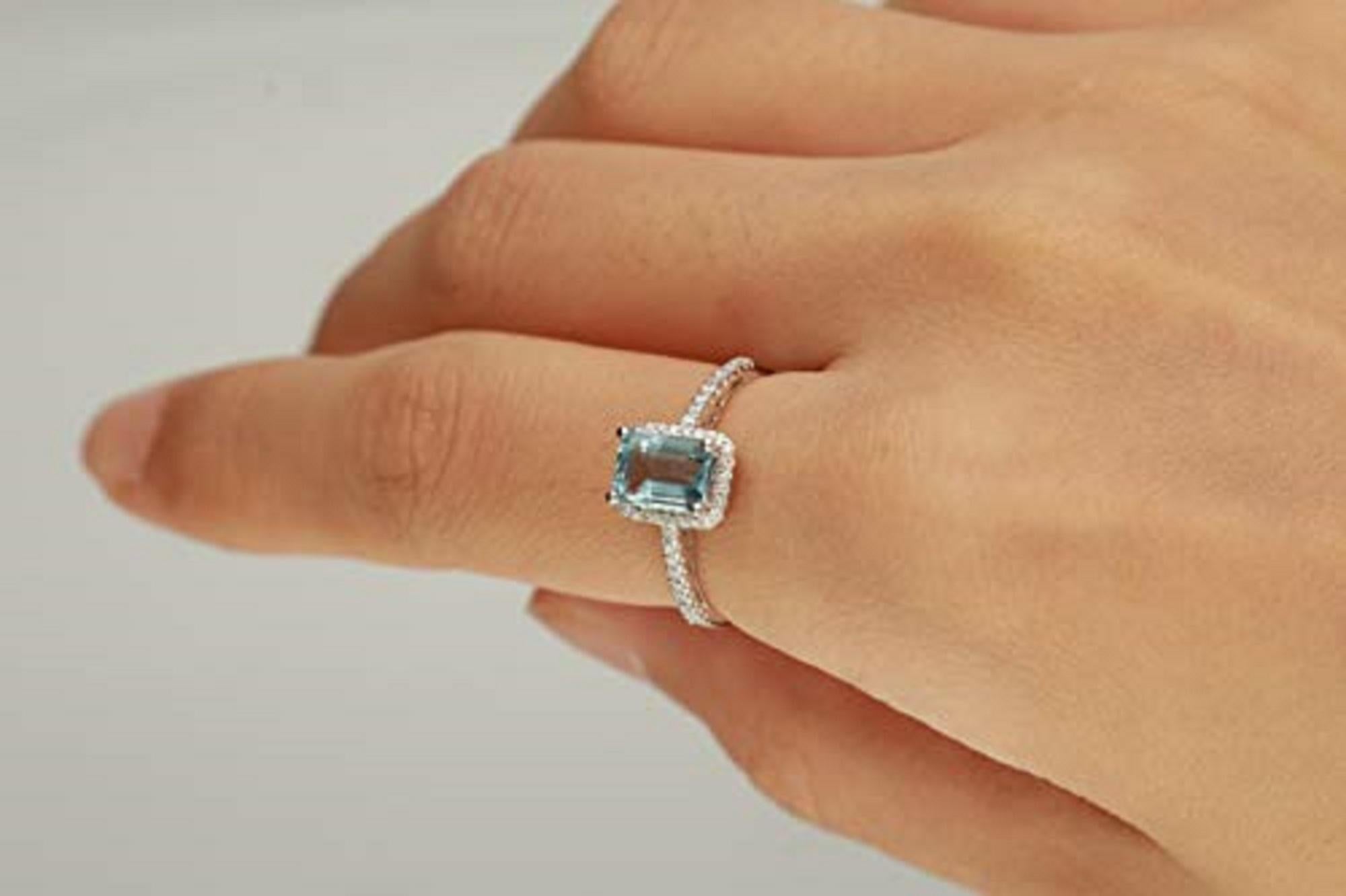 A gorgeous emerald-cut Gin & Grace Genuine aquamarine gemstone rests at the crown of this gorgeous ring. Surrounded by white diamonds that extend down the slender shank, this luminous ring is crafted of 10-karat white gold. Gemstone colors: Blue