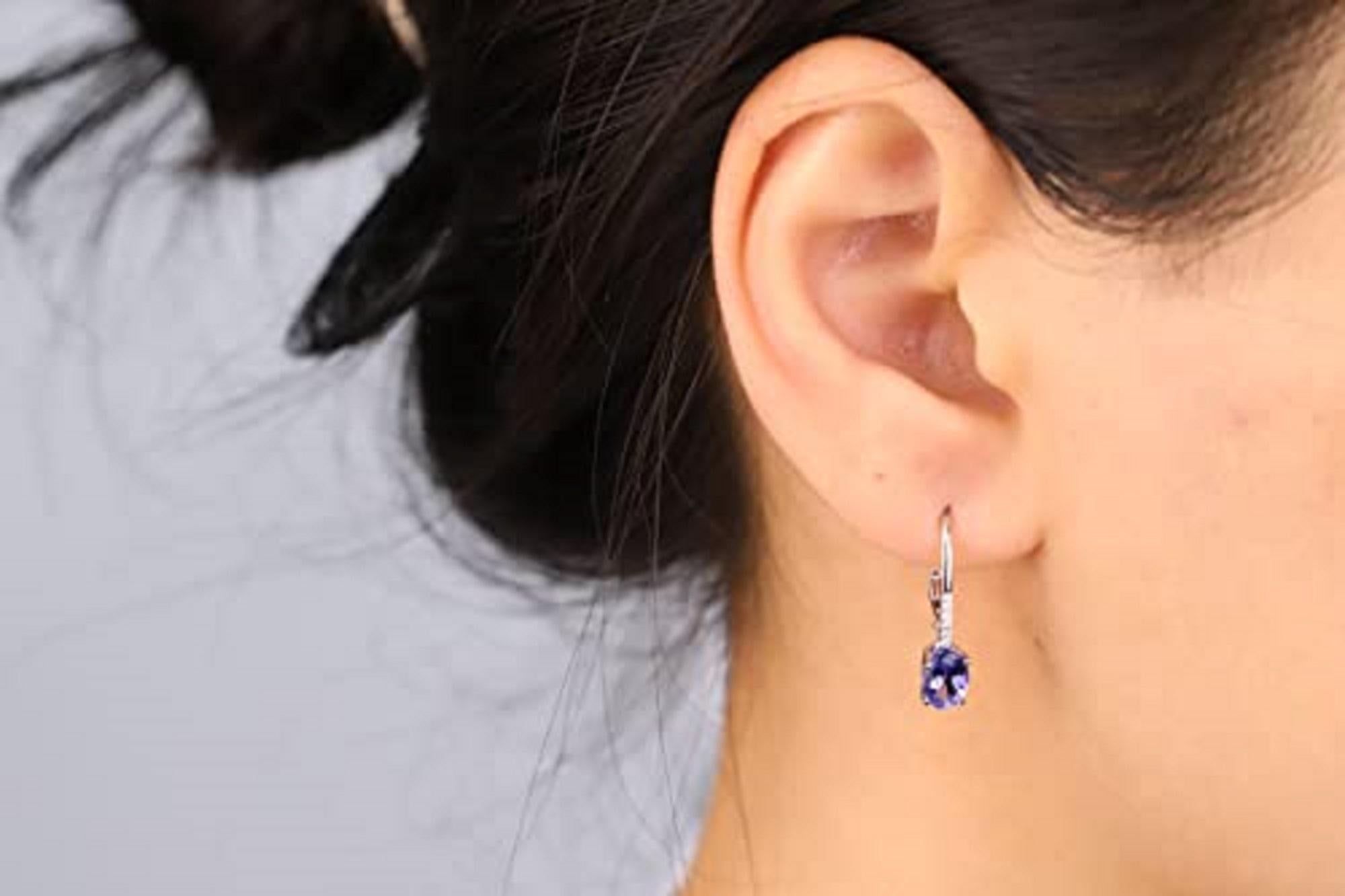 Decorate yourself in elegance with this Earring is crafted from 14-karat White Gold by Gin & Grace. This Earring is made up of 7x5 mm Oval-Cut (2 pcs) 1.62 carat Tanzanite and Round-cut White Diamond (12 Pcs) 0.06 Carat . This Earring is weight 1.48