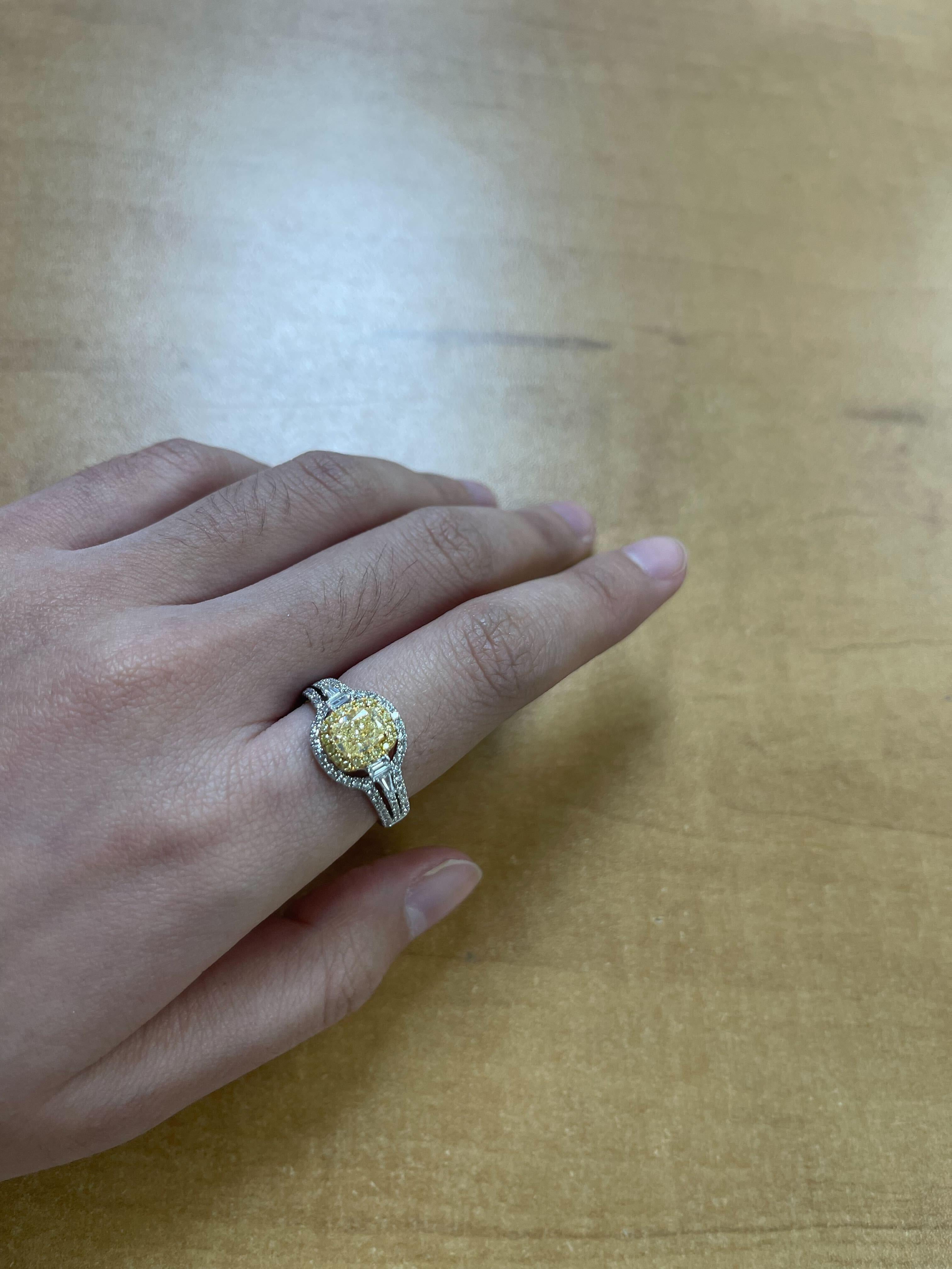 Radieuse et raffinée, cette bague en diamant bicolore 18 carats met en valeur un superbe diamant jaune de 1 carat en son centre, enveloppé de 18 diamants jaunes totalisant 0,12 carat pour plus de chaleur et d'éclat. Quatre diamants baguettes (0,14