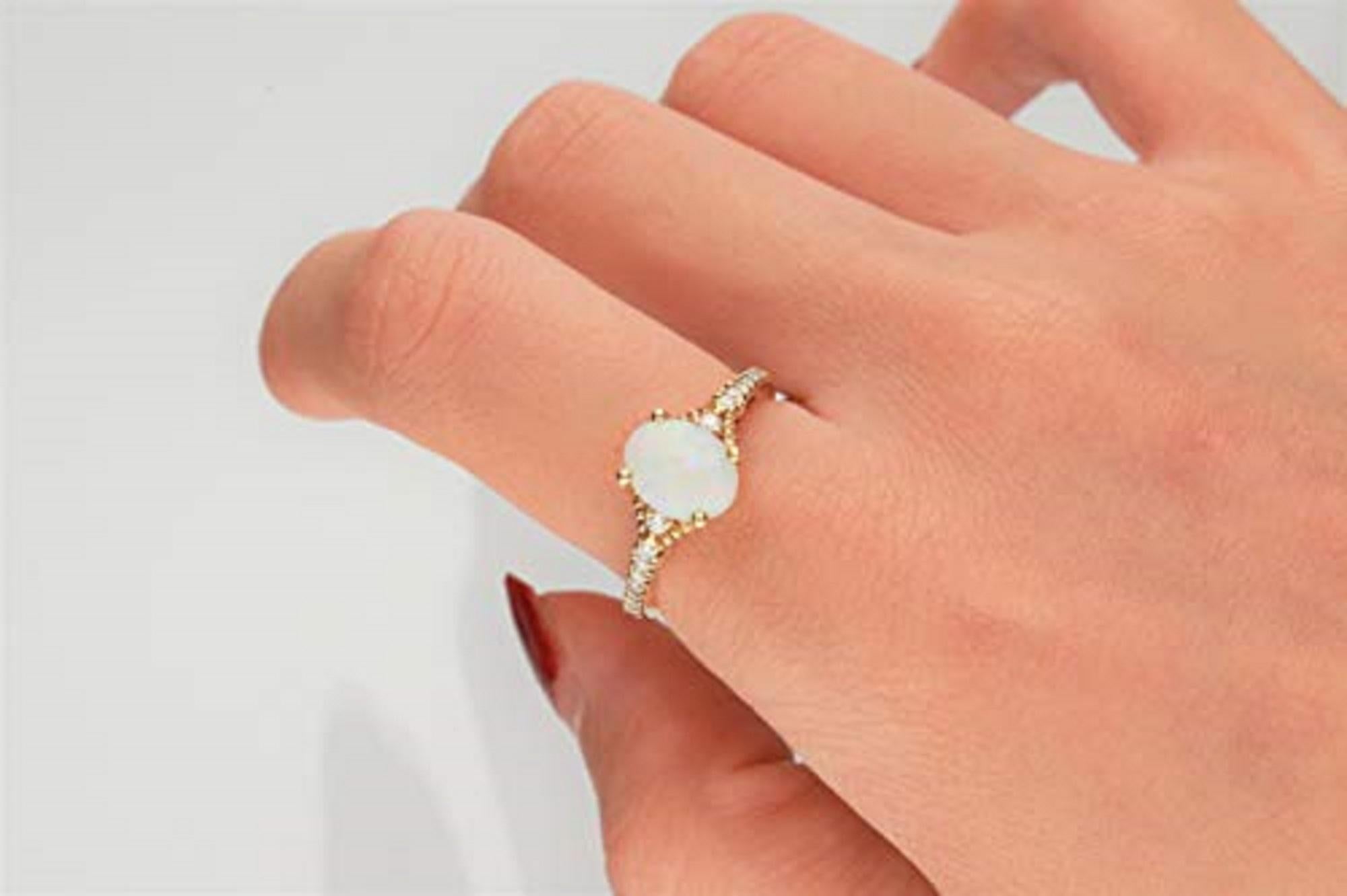 A lustrous oval-cut opal gemstone is set in a marquise-shaped setting of 10K yellow gold. Surrounded by brilliant diamond accent stones, this Gin & Grace ring is finished with a high polish. Gemstone colors: White Gemstone shapes: Oval One prong-set