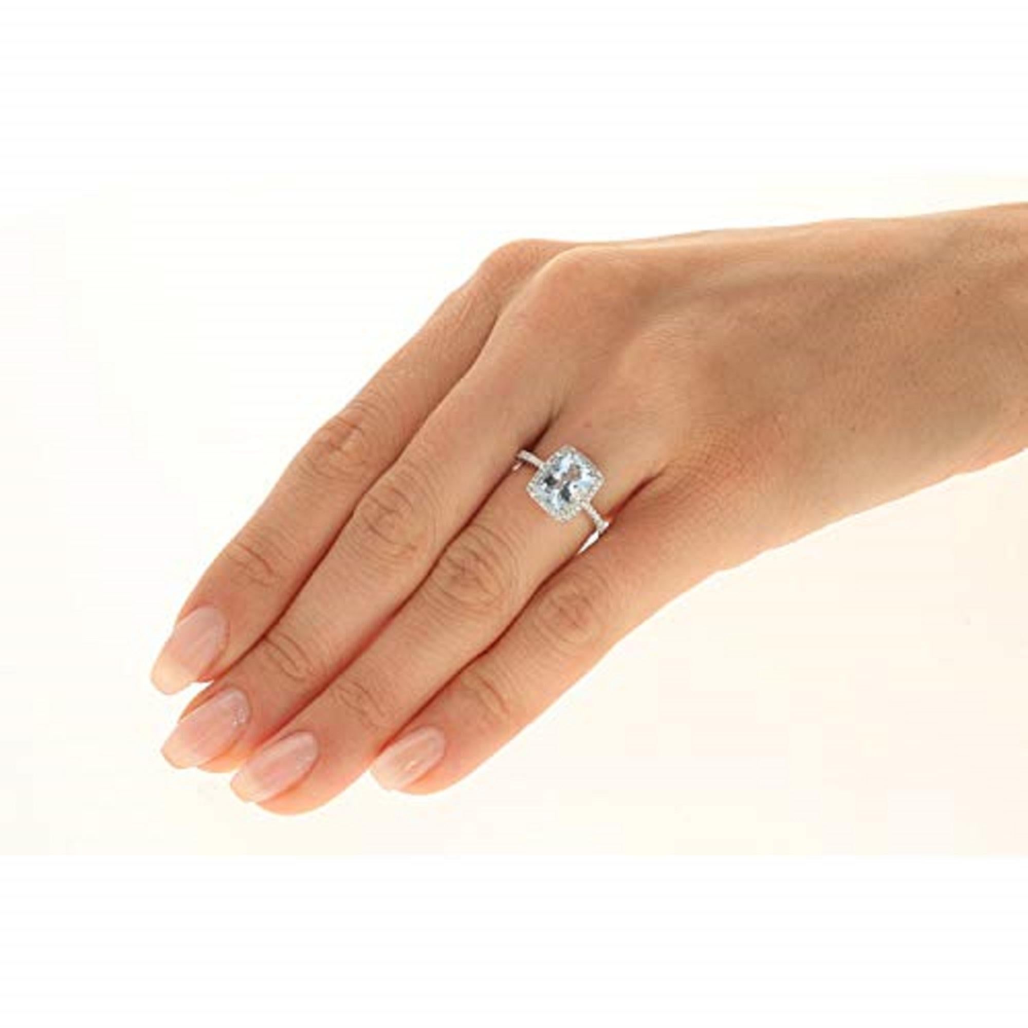 Stunning and delicate, this elegant ring is crafted from sumptuous 14k white gold and features a marvelous cushion cut Gin & Grace Genuine aquamarine. The aquamarine is prong set in the center of the rectangular ring. A rectangular halo of sparkling