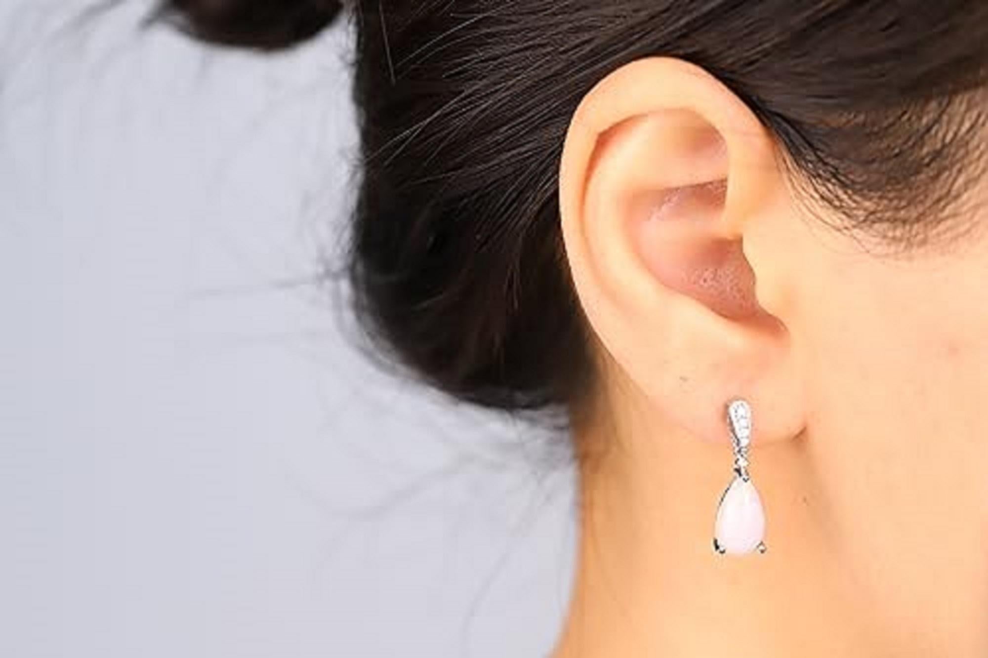 Decorate yourself in elegance with this Earring is crafted from 14-karat Yellow Gold by Gin & Grace. This Earring is made up of 7X12 Opal Oval shaped (2 pcs) 3.17 carat ,Round-cut White Diamond (10 Pcs) 0.08 Carat. This Earring is weight 2.80 grams.