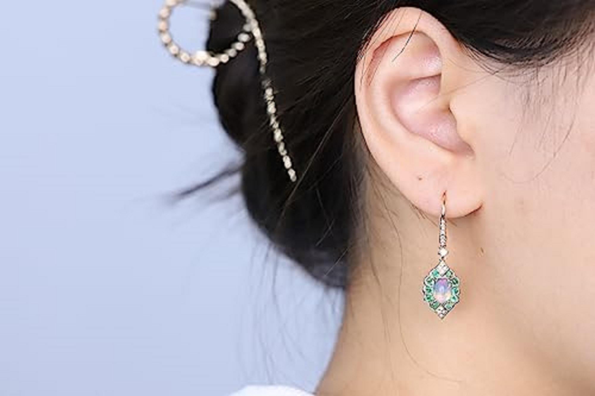 Decorate yourself in elegance with this Earring is crafted from 14-karat Yellow Gold by Gin & Grace. This Earring is made up of 5*7 Cushion-cut Ethiopian opal (2 Pcs) 1.30 carat, 2.0 round-cut Emerald (20 pcs) 0.61 grams and Round-cut White Diamond