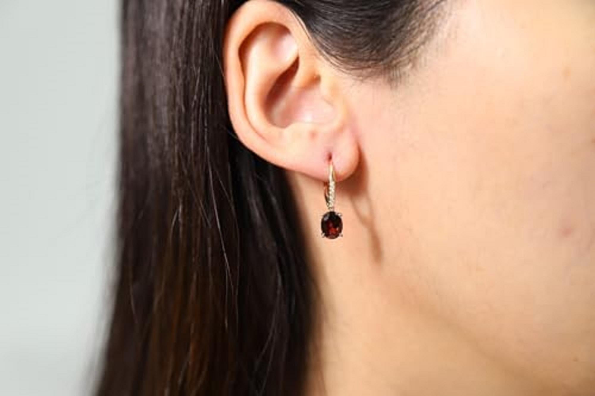 Decorate yourself in elegance with this Earring is crafted from 14K Yellow Gold by Gin & Grace Earring. The jewelry boasts 6X8 Oval-Cut prong setting Garnet (2 pcs) 3.00 Carat and Round-Cut prong setting Diamond (12 pcs) 0.06 Carat. This Earring is