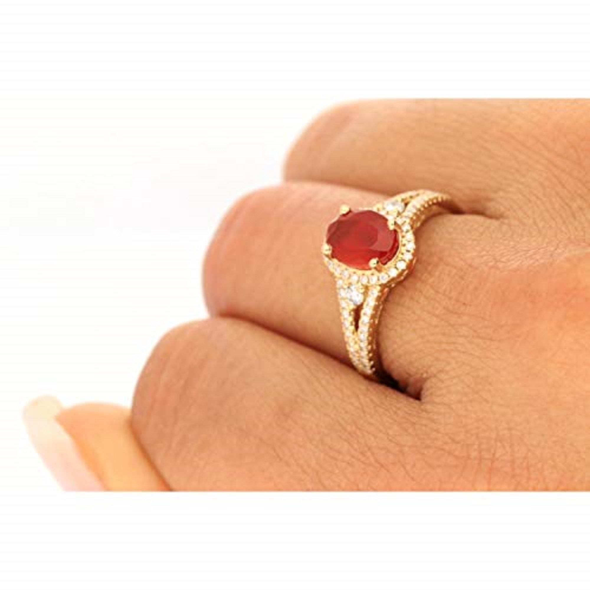 A beautiful and vivid oval-cut Gin & Grace Natural maxi can fire opal is the focal point of this dazzling ring. Exquisitely crafted from 14-karat yellow gold, this gorgeous ring is highlighted by two larger round-cut Natural diamond side stones that