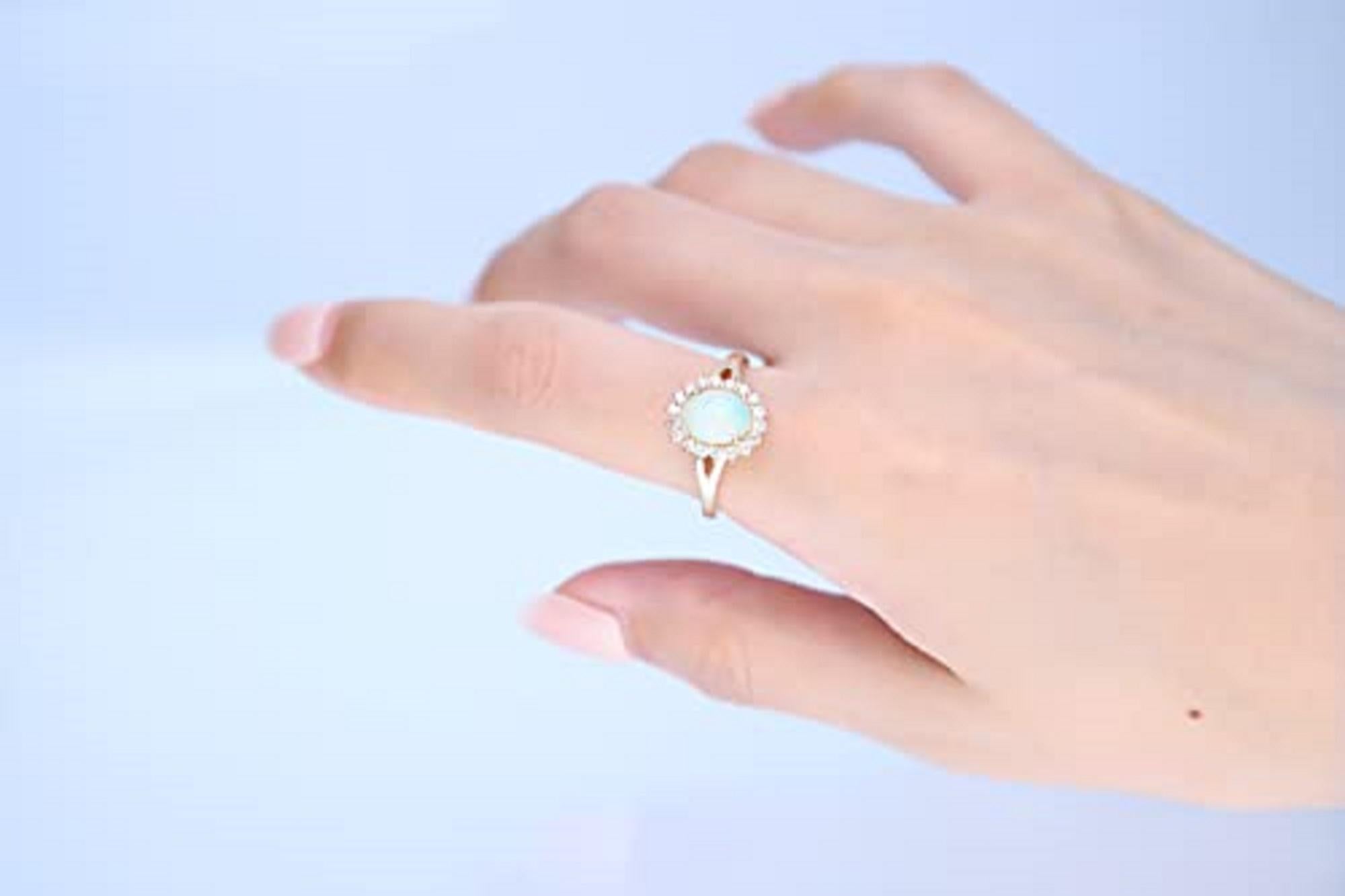Show your stately taste in jewelry with this Natural opal and diamond ring from Gin & Grace The 14-karat yellow gold band complements the opal, which reflects multiple colors to match any outfit. With 18 round-cut diamonds surrounding the opal, the