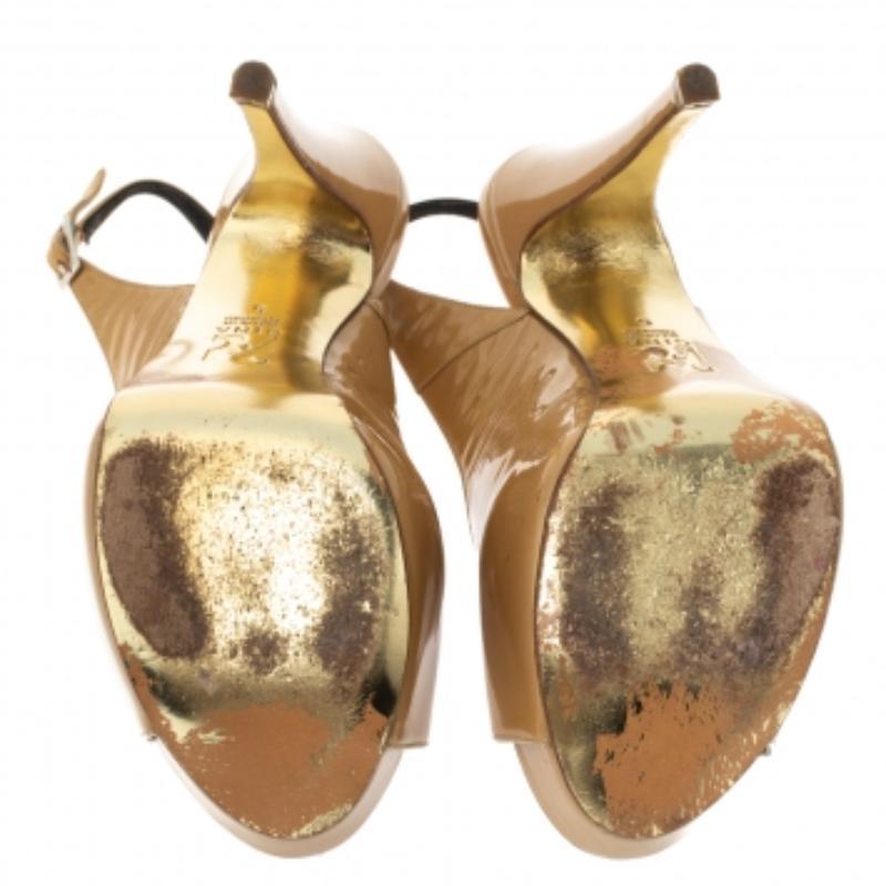 Questi sandali classici di Gina sono un must dell'armadio. Sono in una tonalità neutra di beige e sono realizzate in vernice lucida. Le scarpe sono caratterizzate da punte, plateau, slingback, finiture dorate e tacchi di 13 cm. Sono rifinite con