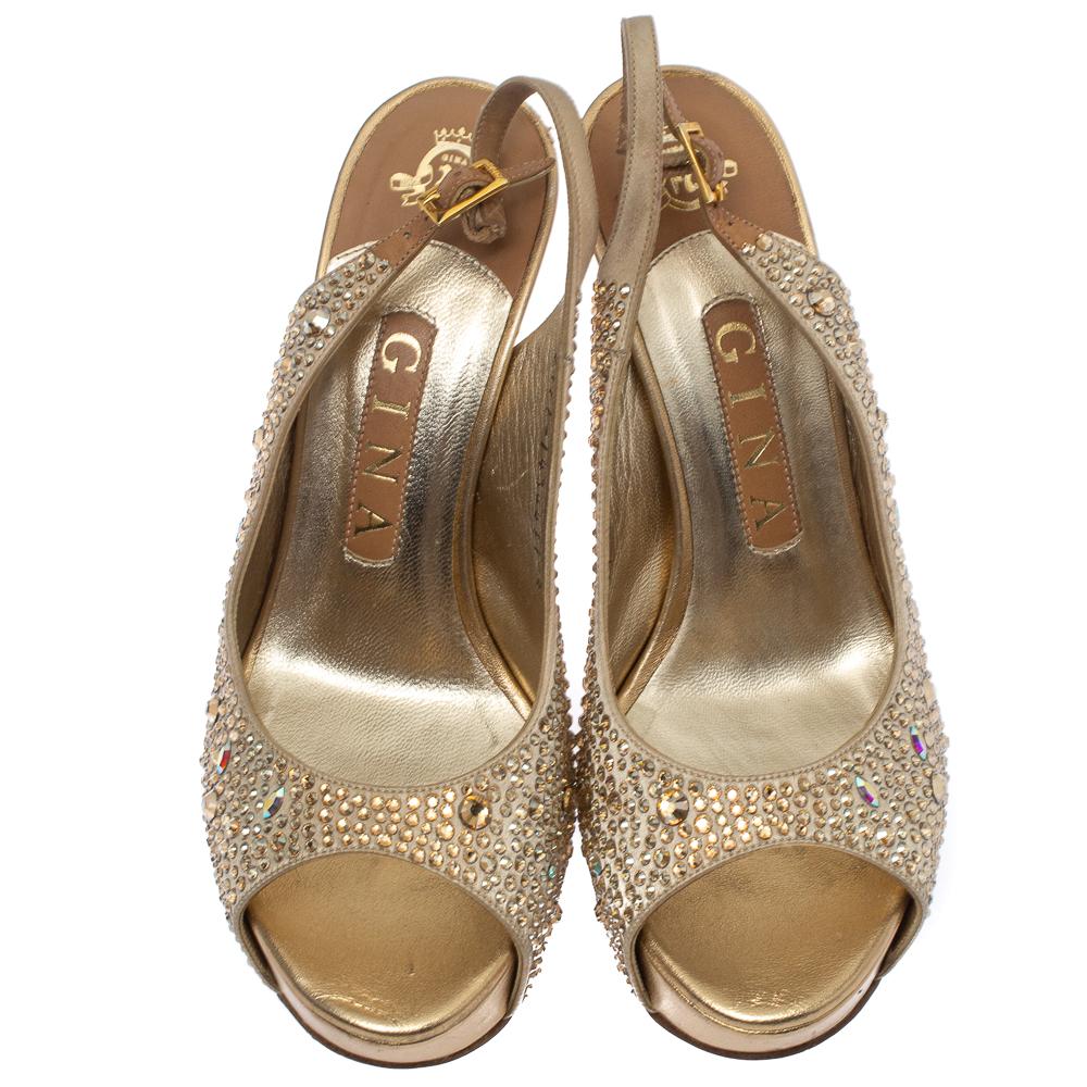Brimming with elegance and beauty, these Gina sandals will instantly amp up your evening ensemble. Crafted from beige-hued satin into a peep-toe silouette, they are embellished with artfully placed crystals all over the exterior. The sandals are