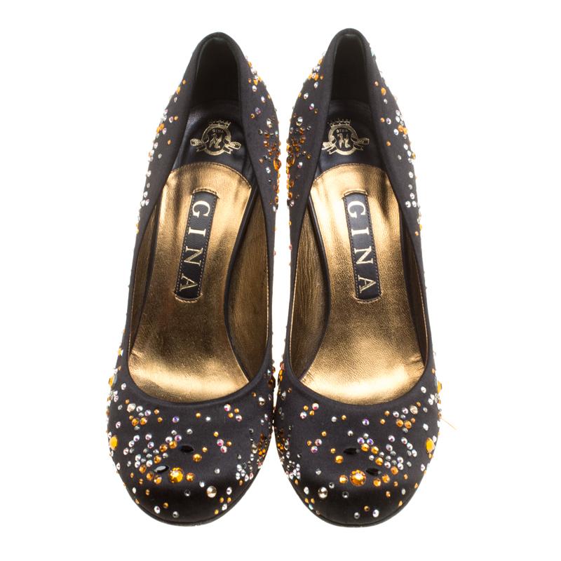 Get your hands on these playful and glamorous pumps from Gina. Rendered in black satin and adorned with crystal embellishments all over, they feature round toes, high heels and a shiny finish. Complete with leather-lined insoles, we like this with a