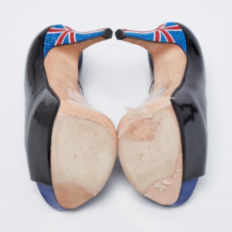 Les magnifiques escarpins de Gina ne manqueront pas d'apporter une touche de classe à toutes vos tenues. Confectionnés en cuir verni noir et montés sur de hauts talons ornés de cristaux, ces escarpins s'accompagnent de peep toes, de plateformes et