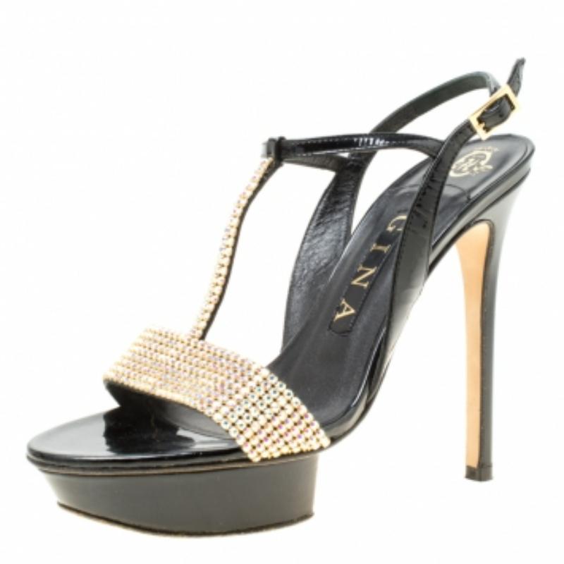 Ces sandales Gina vous couperont le souffle par leur beauté et leur style ! Ces sandales noires sont confectionnées en cuir et présentent une silhouette à bout ouvert. Elles sont dotées de brides d'empeigne ornées de cristaux, de brides de cheville
