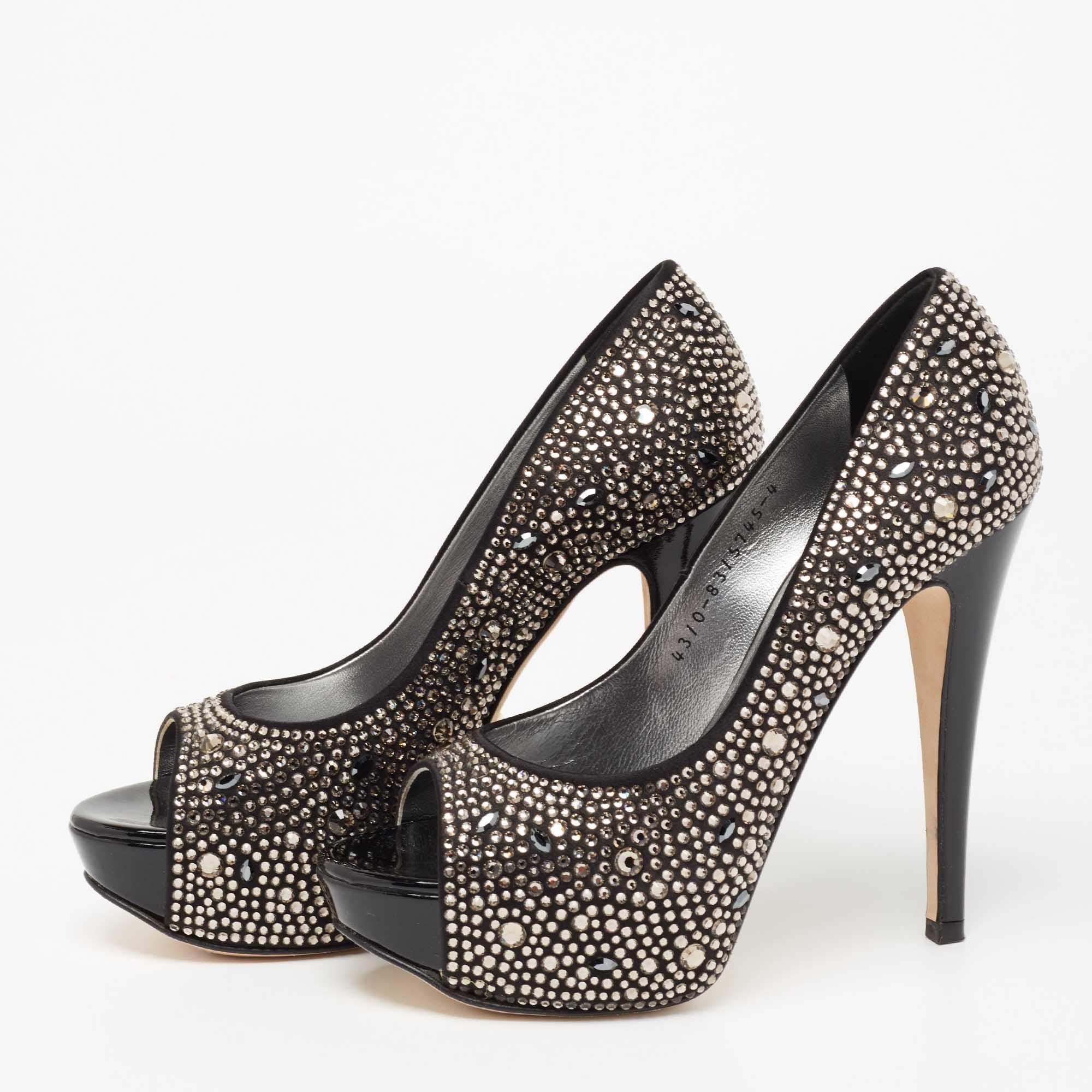 Take every step with elegance and style in these pumps from the House of Gina. They are crafted meticulously using black satin, which is highlighted with crystal embellishments. They showcase platforms, peep toes, and tall heels. These pumps will be