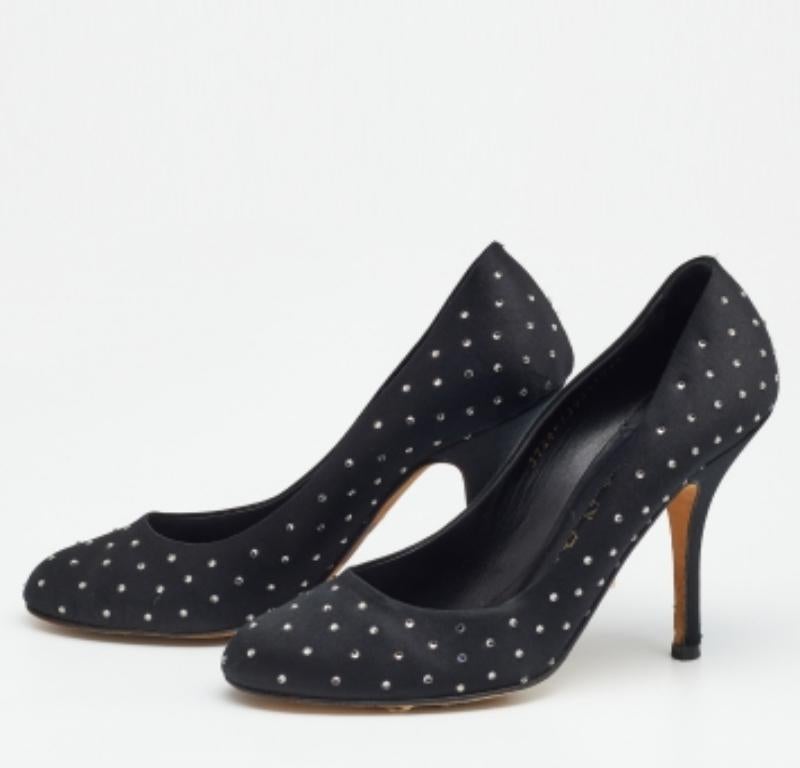 Prepárate para ir absolutamente espectacular a la fiesta con estos zapatos de salón de la casa Gina. Fabricados en satén negro, estos zapatos de salón están bellamente adornados con cristales por todas partes y colocados sobre tacones de 10,5 cm.