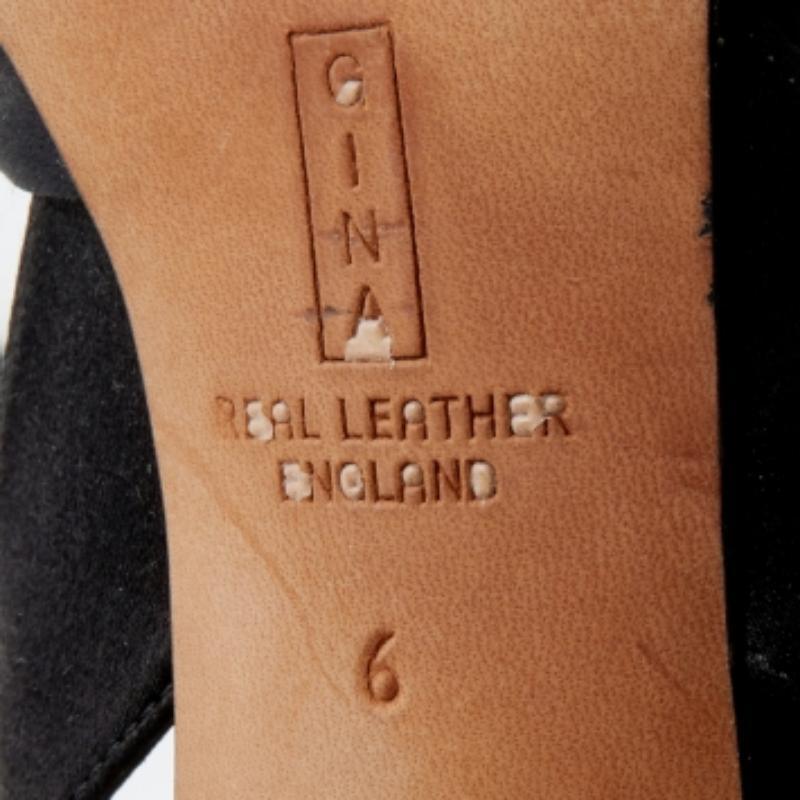 Gina ist bekannt für anmutige Designs, und das Label ist ein Synonym für Opulenz, Weiblichkeit und Eleganz. Diese Sandalen sind aus schwarzem Satin gefertigt und haben eine offene Zehensilhouette, die durch die Kristallverzierungen auf dem