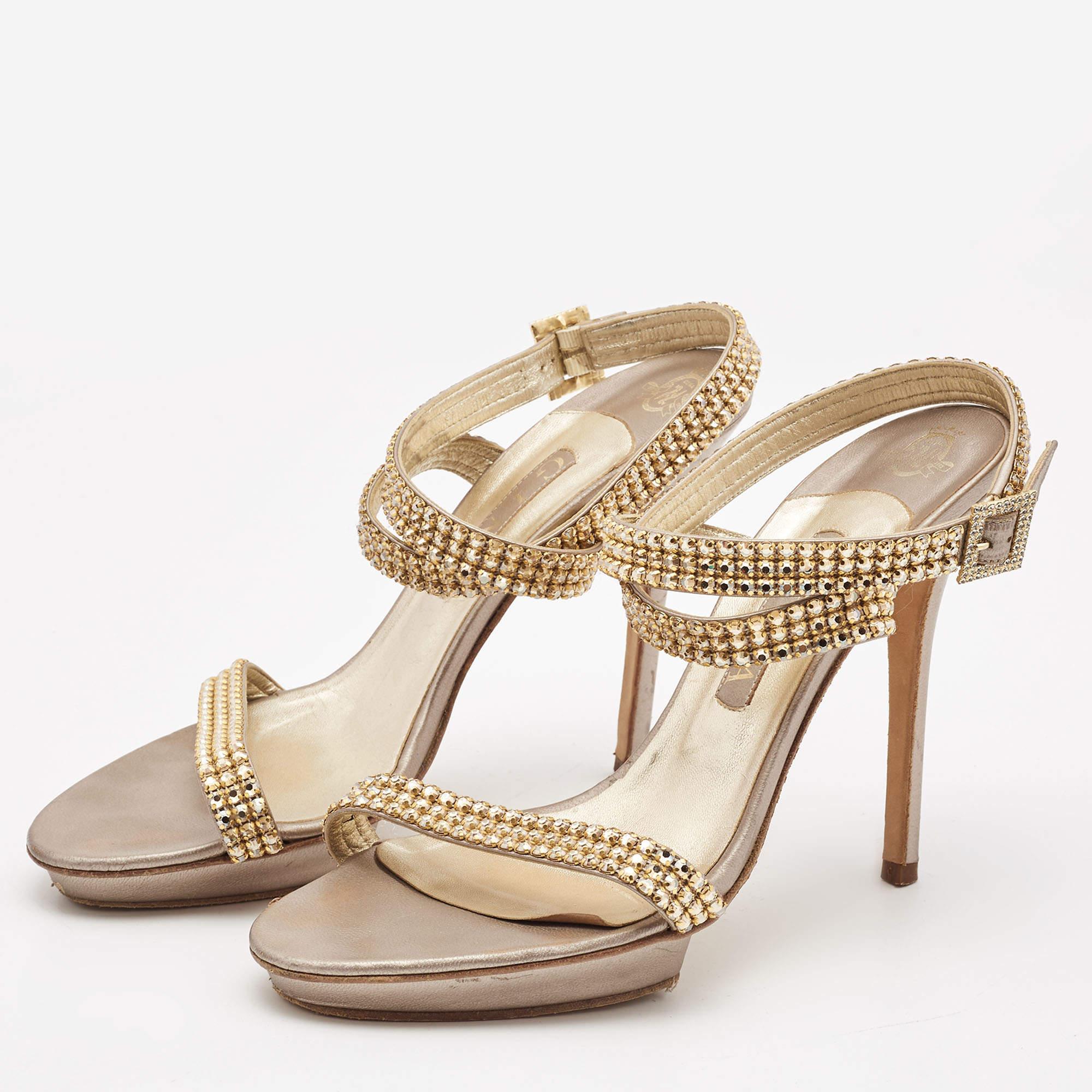 Choose these stylish sandals from the house of Gina for an effortlessly fashionable look. Made from leather  they come with open toes  platforms  buckled ankle straps  crystals  and slim heels.