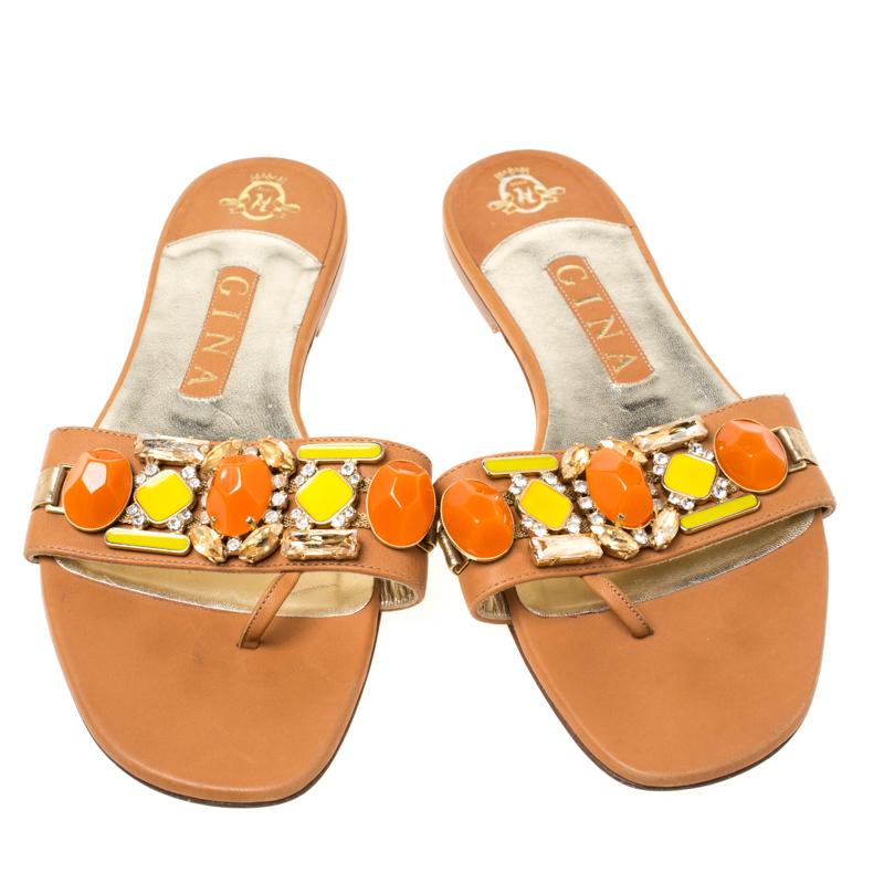 Delicati abbellimenti impreziosiscono questi sandali piatti di Gina. Sono realizzate in pelle marrone e presentano pietre colorate e cristalli scintillanti sul cinturino della tomaia. Indossale per dare un tocco di grazia a una serie di look da