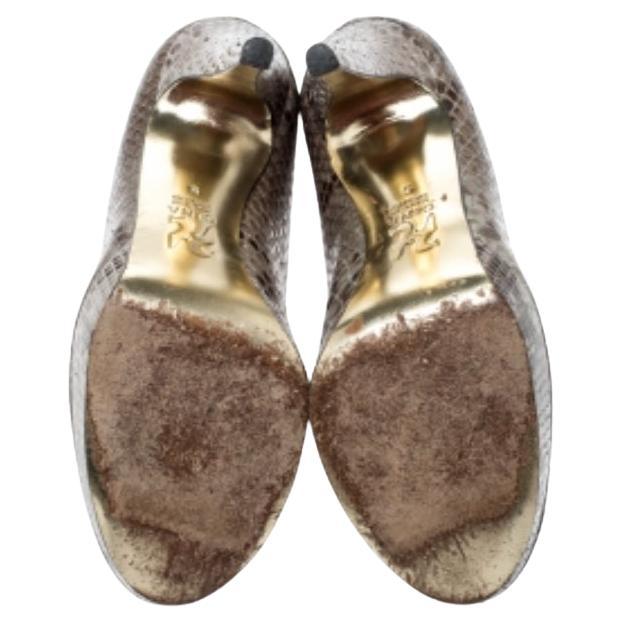 Scegli queste décolleté eleganti e ben tagliate della casa Gina. Sono realizzate in pelle di pitone marrone e si bilanciano su plateau e tacco di 12 cm. Non puoi mai sbagliare con questo splendido paio.
