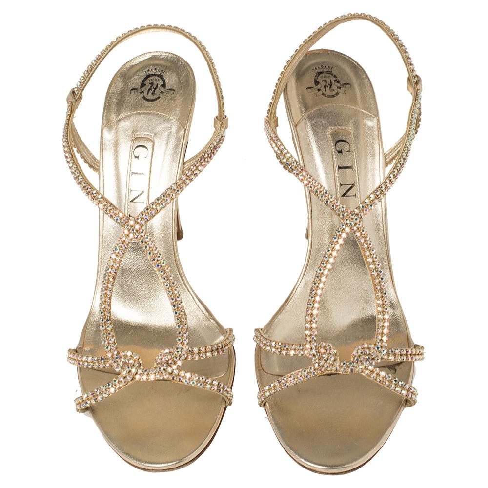 Exude glamour with these gold Gina sandals. Crafted in leather, they come embellished with crystals on the strappy uppers. The slingback sandals are elevated on 10.5 cm heels.

