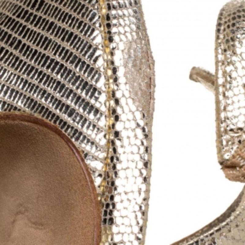 These lovely Gina sandals are ideal with formals as well as casuals. Crafted from gold lizard-embossed leather, they are styled with peep toes, 12.5 cm heels, and slingbacks. They are finished with leather-lined insoles and platforms for maximum