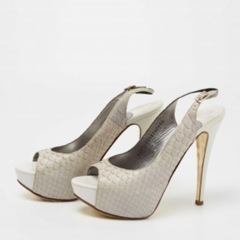 Il tacco di 12,5 cm e il plateau di questi sandali Gina aggiorneranno senza sforzo il tuo outfit. Realizzate in pelle di pitone in una silhouette peep-toe, presentano una chiusura con fibbia alla caviglia, hardware color argento e un comodo plantare.