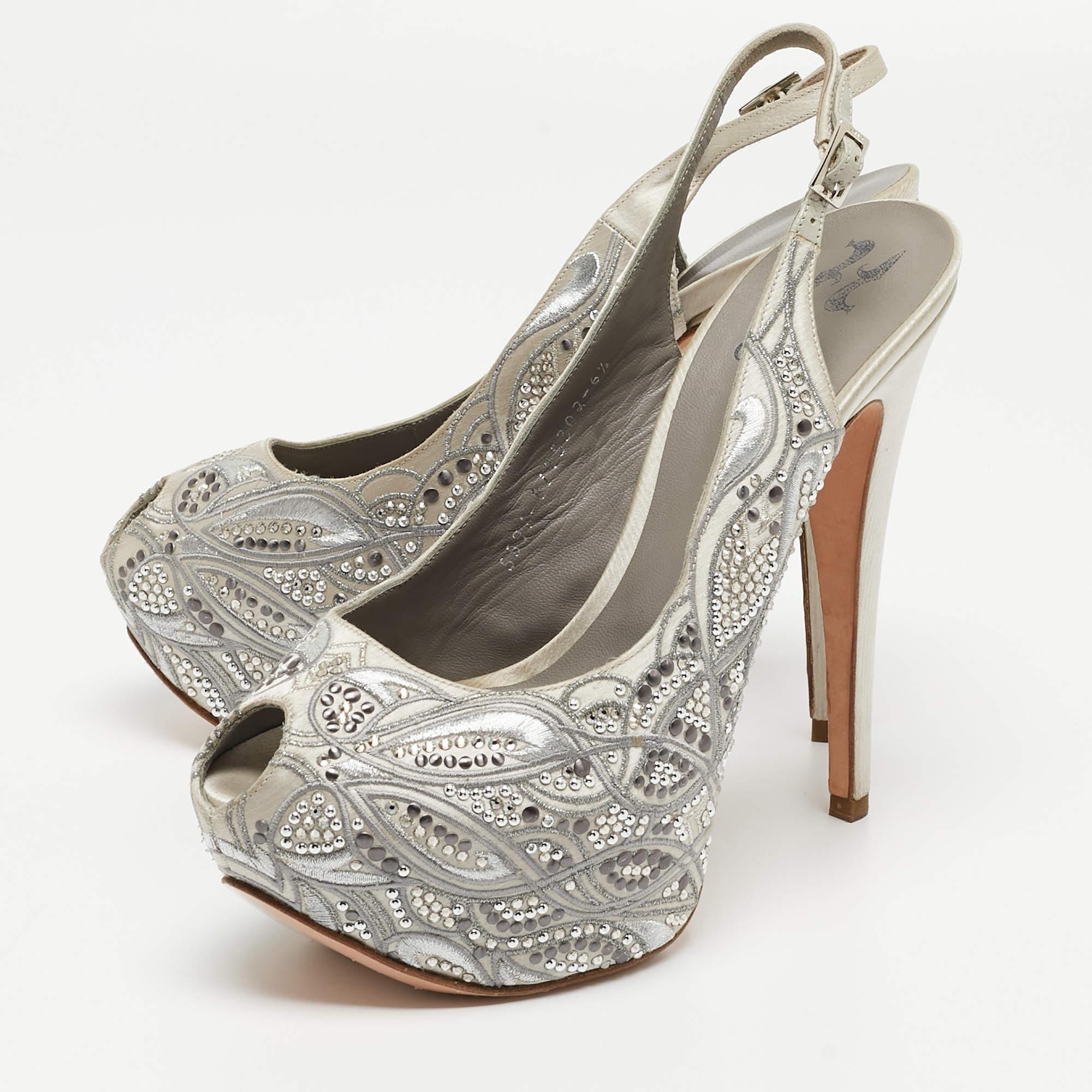 Questi sandali Gina sono una scelta ovvia per la tua prossima festa serale. Realizzate in raso, sono impreziosite da decorazioni in cristallo e presentano una silhouette peep-toe. Il tacco di 15,5 cm e il plateau di queste scarpe ti conferiranno un