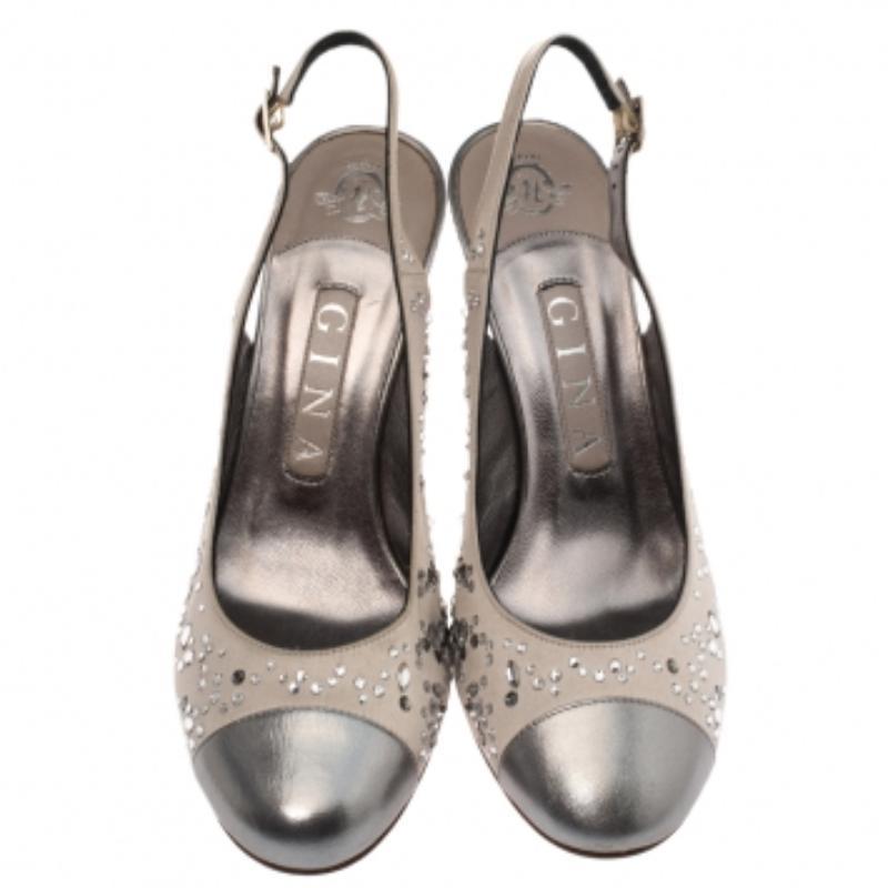 Metti le mani su questi splendidi sandali di Gina! Sono realizzate in raso e pelle e presentano abbellimenti in cristallo. Le scarpe sfoggiano delle slingback con fibbie e sono dotate di comode solette foderate in pelle e di un tacco di 10,5 cm.