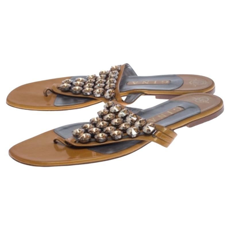 Forma e comfort si uniscono in questi sandali infradito di Gina. Realizzate in pelle, presentano graziose borchie di cristallo sulla tomaia. Le solette sono foderate in pelle e presentano i timbri dell'etichetta Gina.