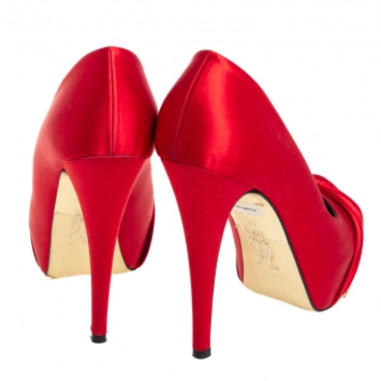 Elegance and grace all in one! These red Gina pumps have been crafted from rich satin and styled with ruched detailing on the toes. They are equipped with comfortable leather-lined insoles and elevated on concealed platforms and 13 cm heels. Pair