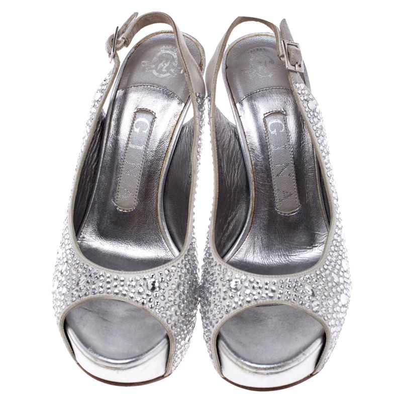 These Gina sandals feature a silver satin body with crystal embellishment all over that makes them apt for those celebratory occasions. They are set on towering heels balanced with a platform sole and comes with a slingback strap.

Includes: