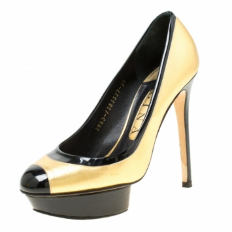 Diese umwerfenden Pumps von Gina sind aus goldfarbenem Leder sowie schwarzem Lackleder gefertigt und mit Plateau und 12,5 cm Absatz versehen. Tragen Sie dieses goldene Paar zu Ihrer nächsten Party und werden Sie zum Mittelpunkt der Aufmerksamkeit.