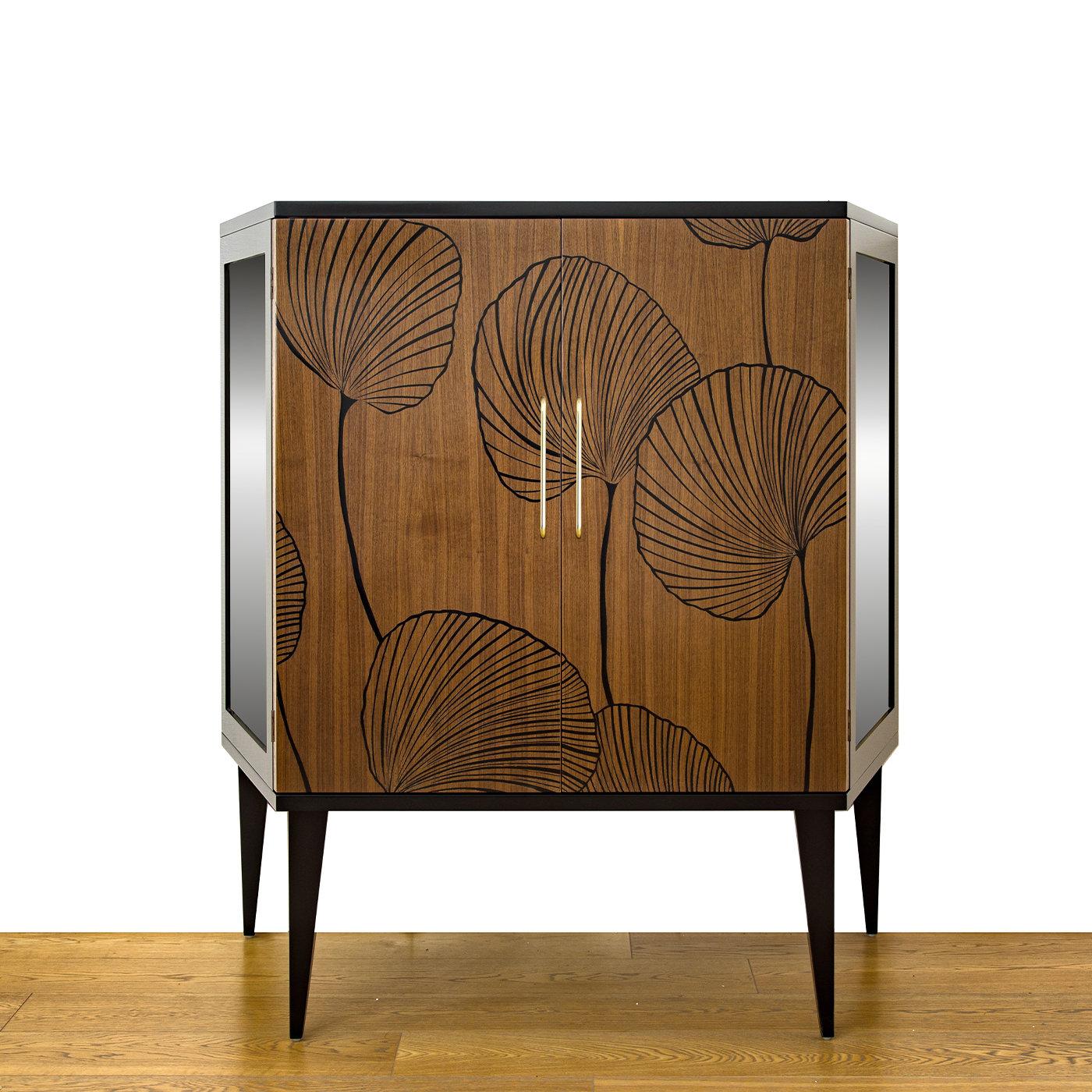 This lovely walnut wood shoe cabinet shows that practicality can be elegant. The cabinet features two walnut wood doors decorated with large, black Ginkgo leaves and brass handles, while the sides are in glass and Vienna straw for increased